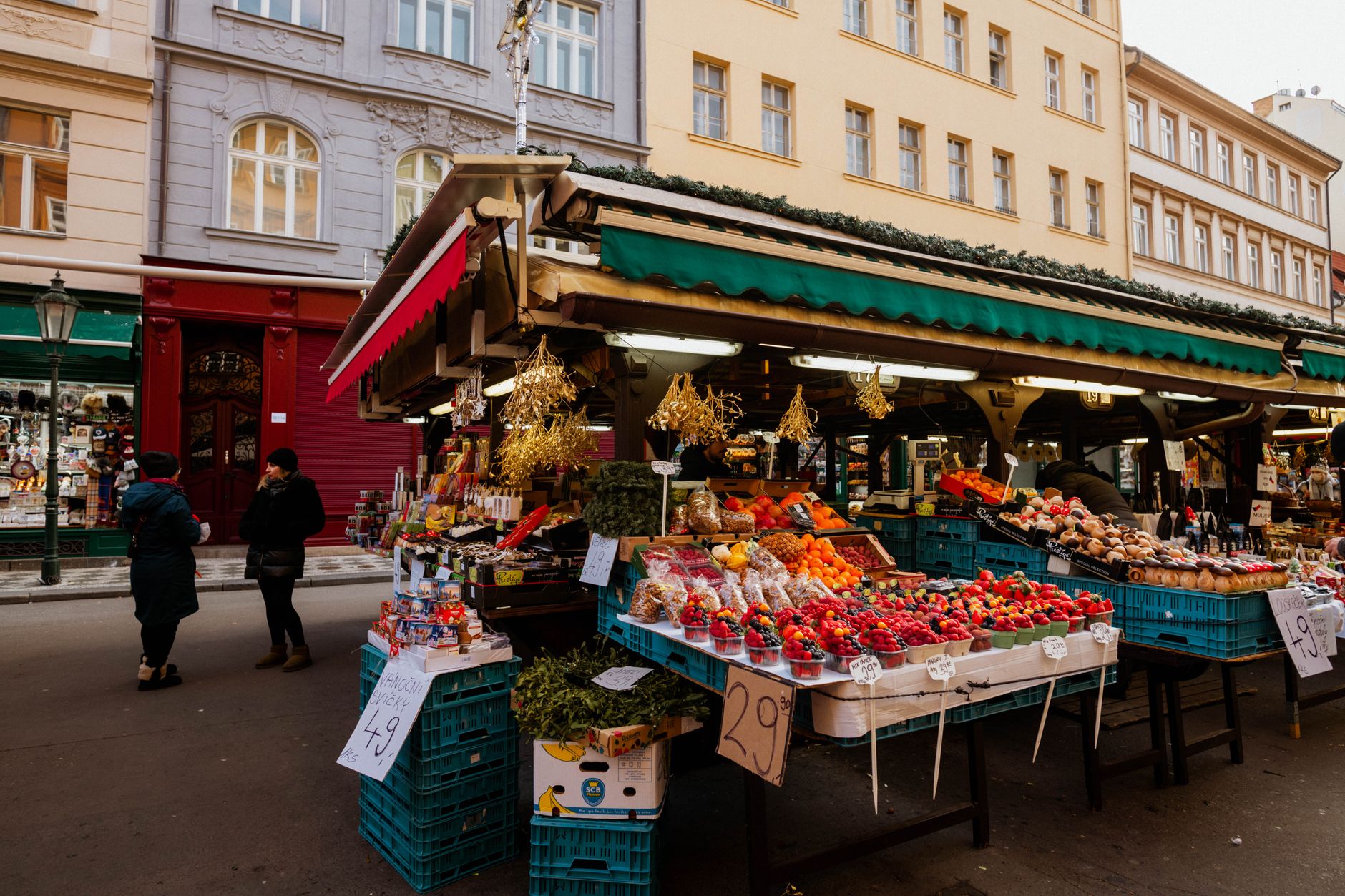 Produce vendors work among colorful crates and clearly divided stalls in a wholesale market.