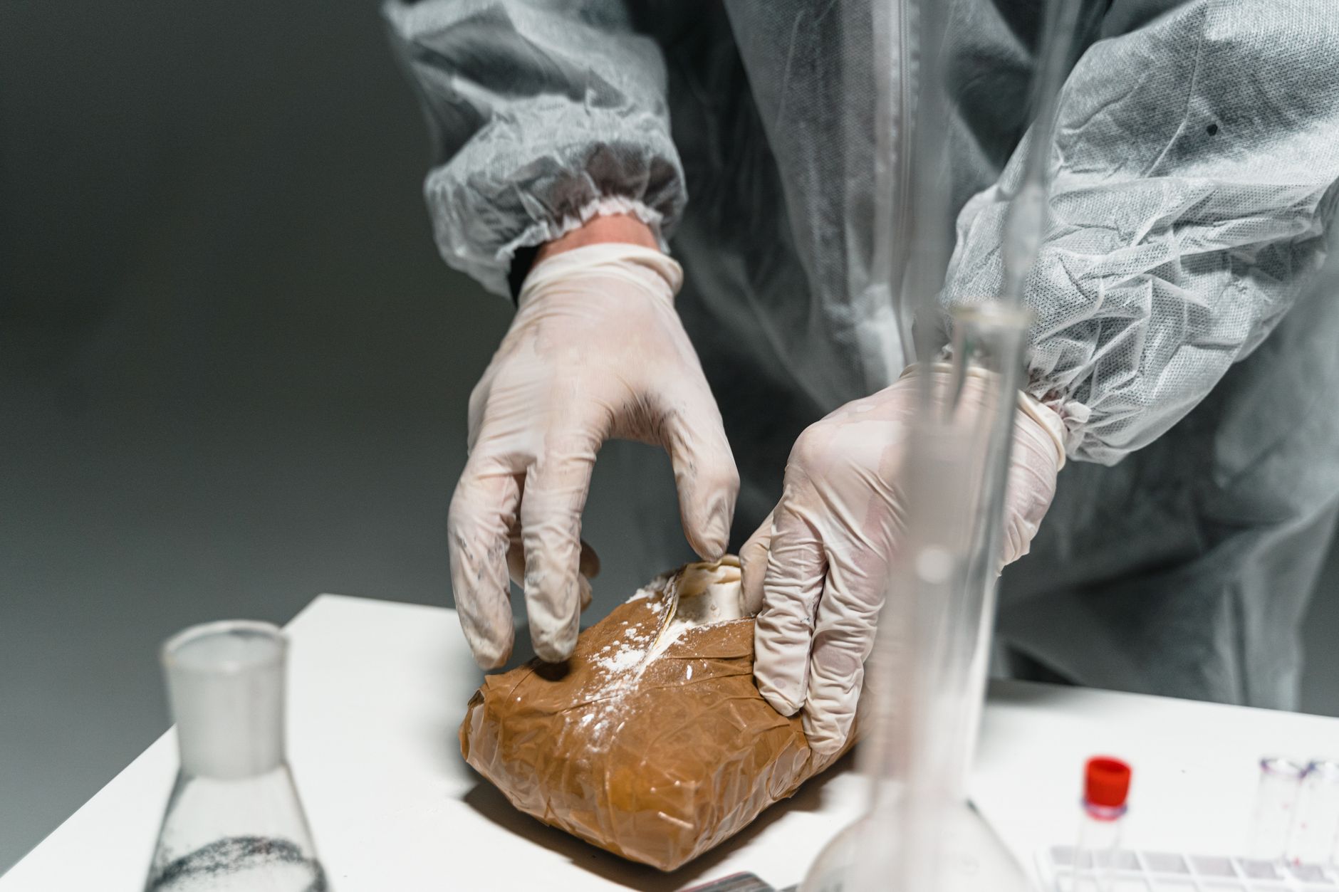 Gloved hands sealing a sterile pouch show how package materials can wrinkle, scuff, or mis-seal long before a handling system throws a fault.