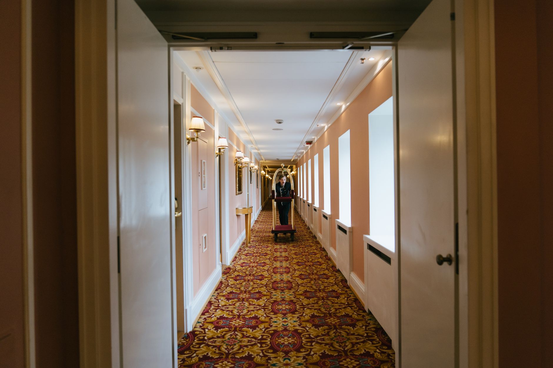 A busy back-of-house hotel corridor with carts and equipment, showing the constrained paths that complicate banquet support work.