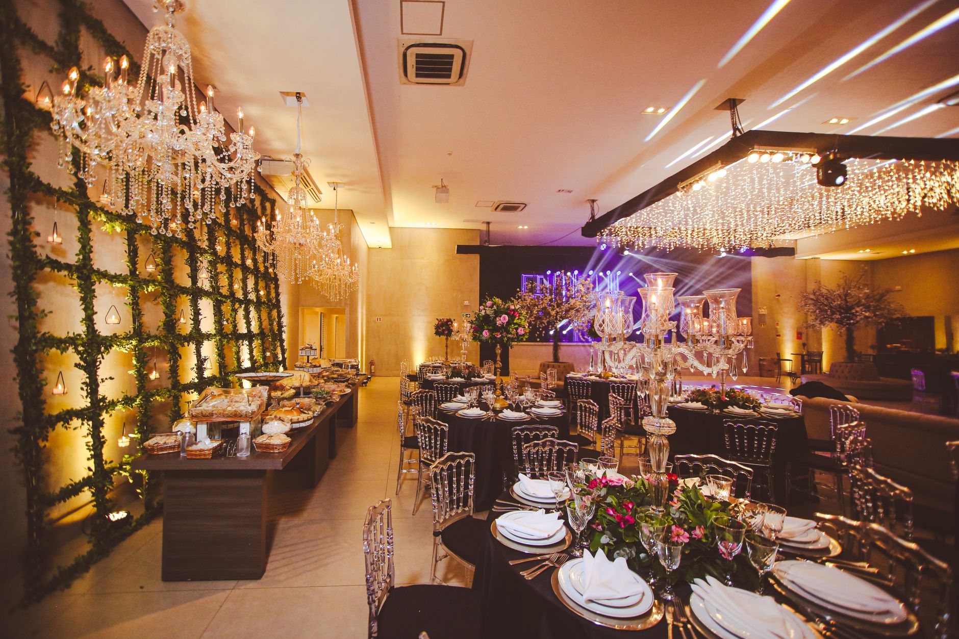 Rows of banquet tables and chairs being arranged inside a large hotel ballroom before an event reset.