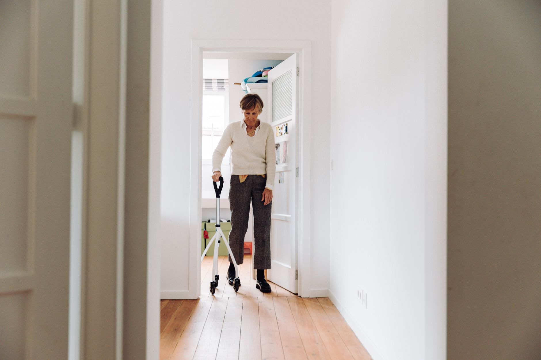 A quiet senior living corridor that conveys the long, repeatable indoor routes used for laundry transport.