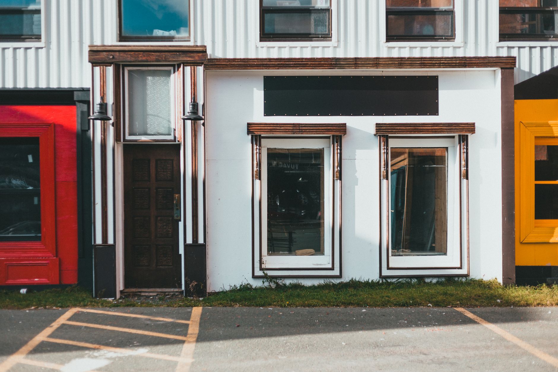 Row of retail storefronts, evoking multi-location operators choosing between one-site and portfolio robot pilots.