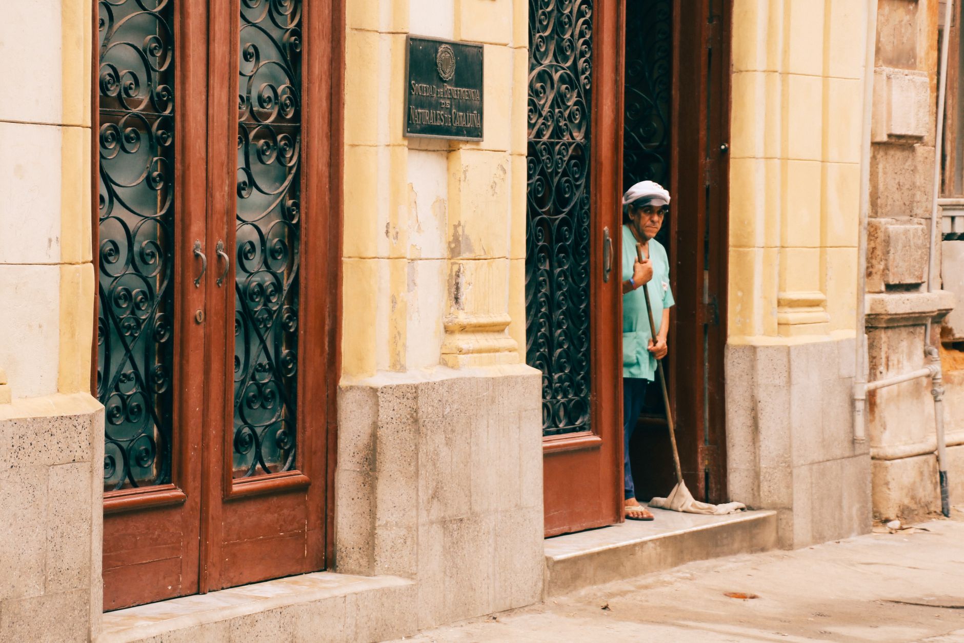 A janitor mopping a long hallway, illustrating the physically demanding nature of manual cleaning work.