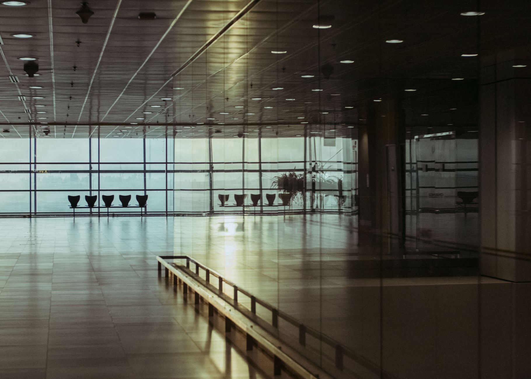 A vast, clean, and empty airport terminal, representing the large-scale environments that benefit from robotic cleaning crews.