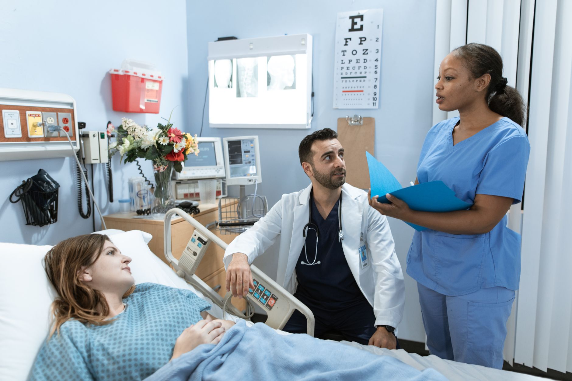 Nurses walking together down a busy hospital ward corridor