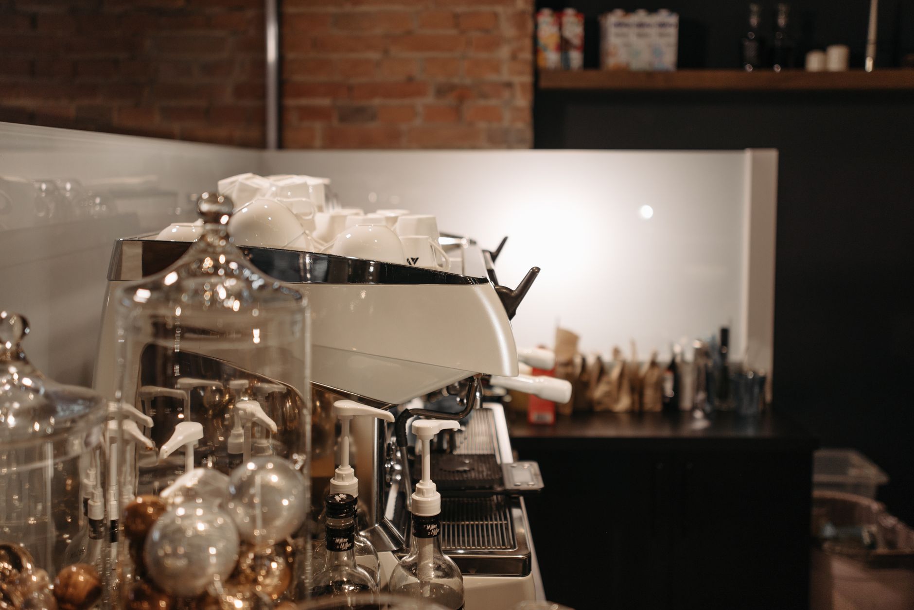 A professional, multi-group head espresso machine sits on a cafe counter, ready to dispense coffee.