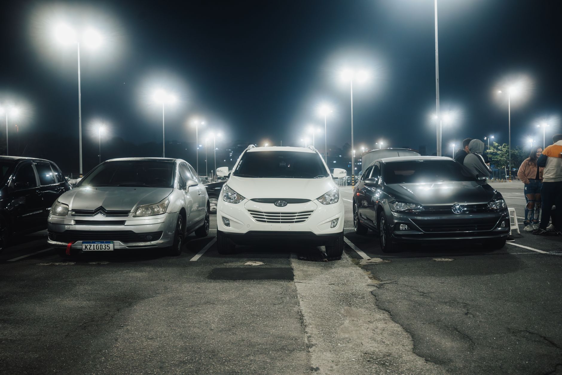 A large parking area at night shows the kind of perimeter and entrance coverage challenge that can push security ahead of cleaning.