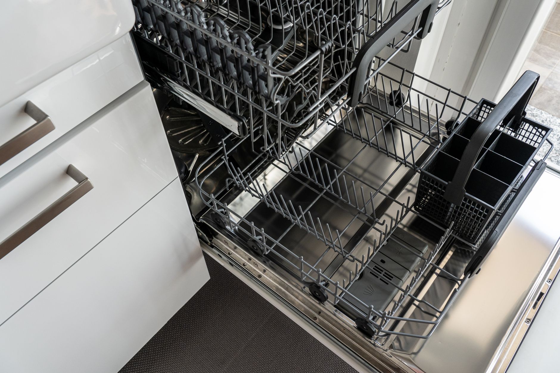 The clean, stainless-steel dishwashing area of a commercial kitchen where dirty trays are received for sanitation.