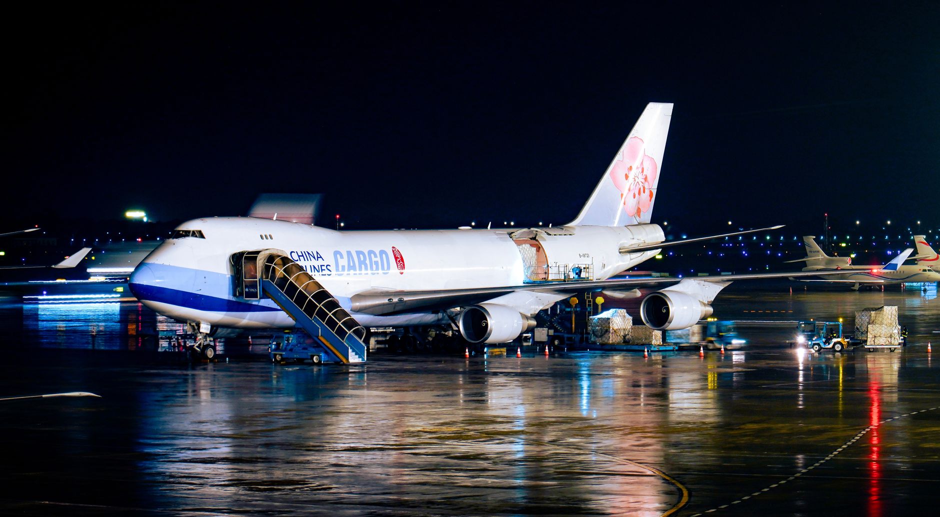 Aircraft tied down on a ramp at night where marshaling and fueling stay human tasks.