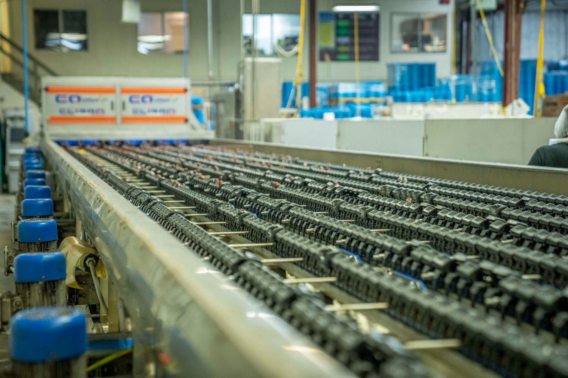 A complex network of conveyor belts stands idle in a large logistics facility, showing how a single point of failure can halt an entire system.