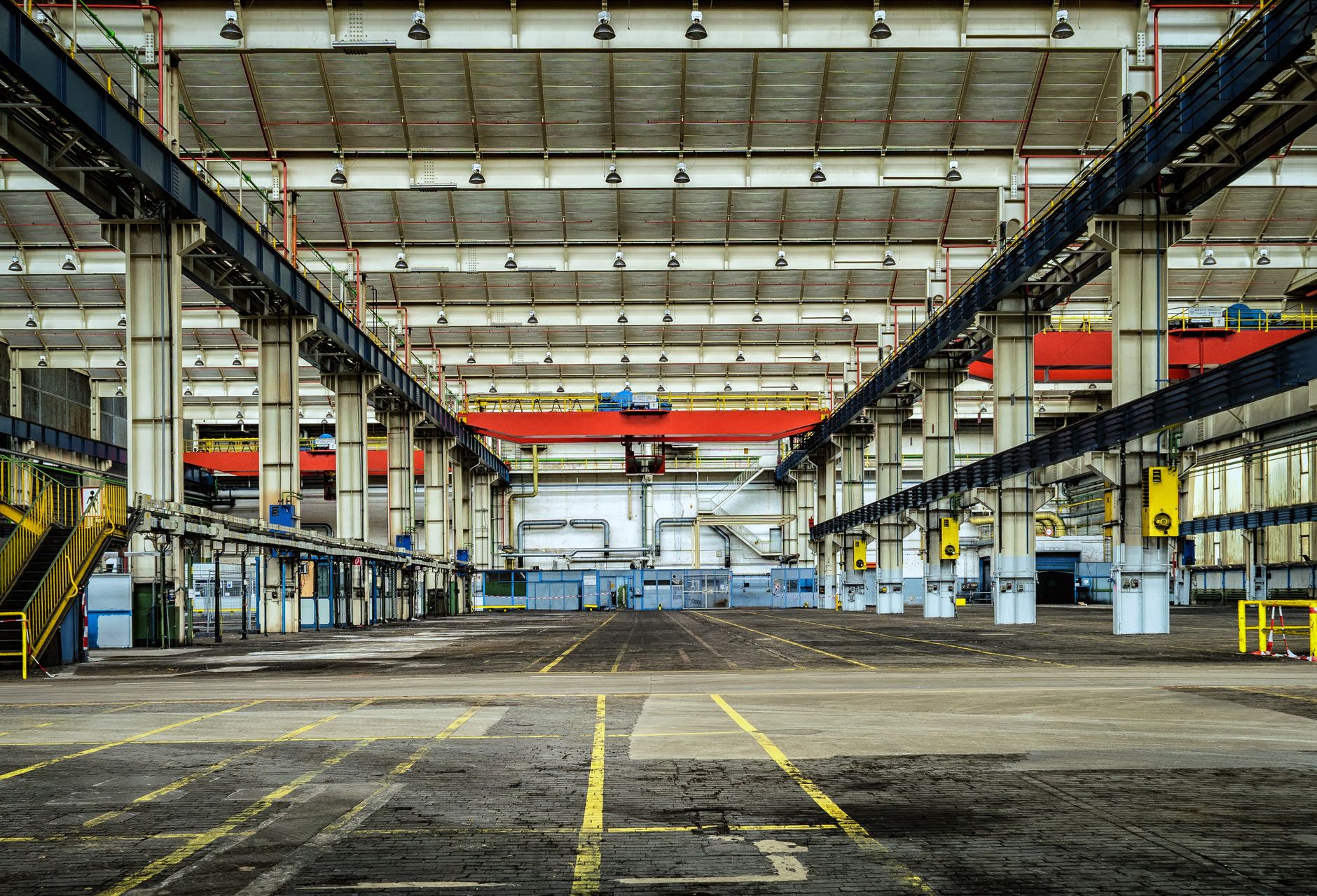 An empty factory floor with machinery covered and silent, illustrating the high cost of operational downtime.