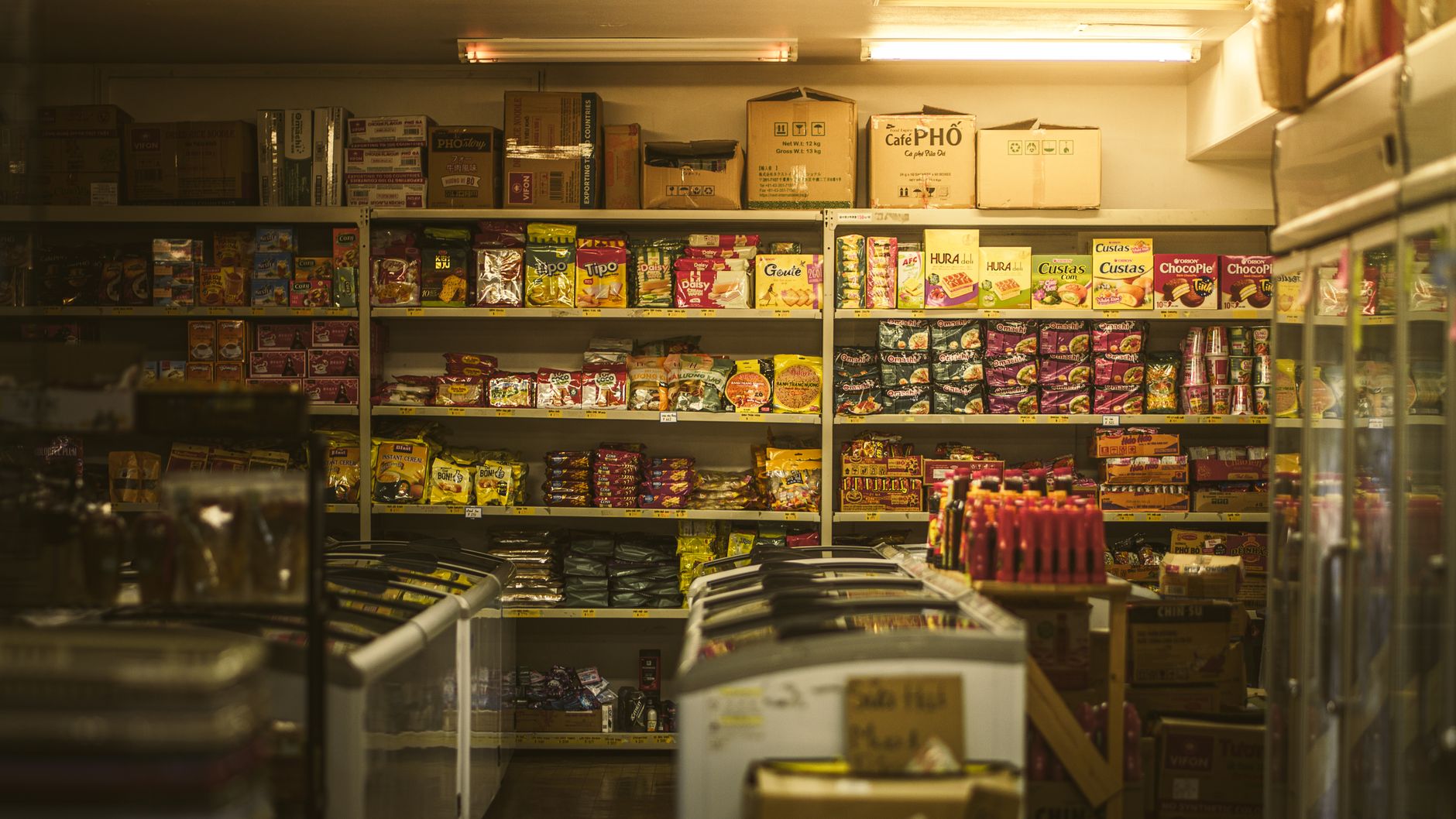 A quiet late-night retail aisle that conveys the overnight cleaning window inside a 24-hour travel plaza.