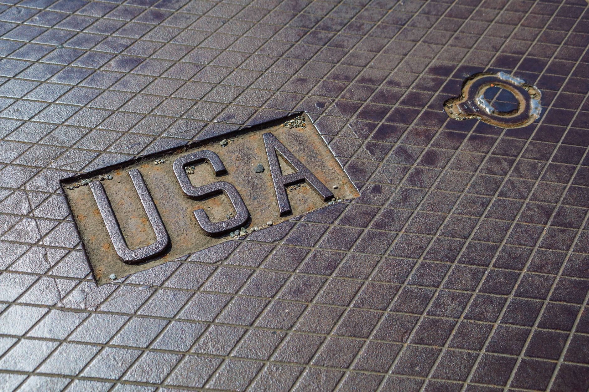 Wet concrete flooring and a drain line in a commercial work area, similar to the slick, debris-prone zones on a floral warehouse floor.