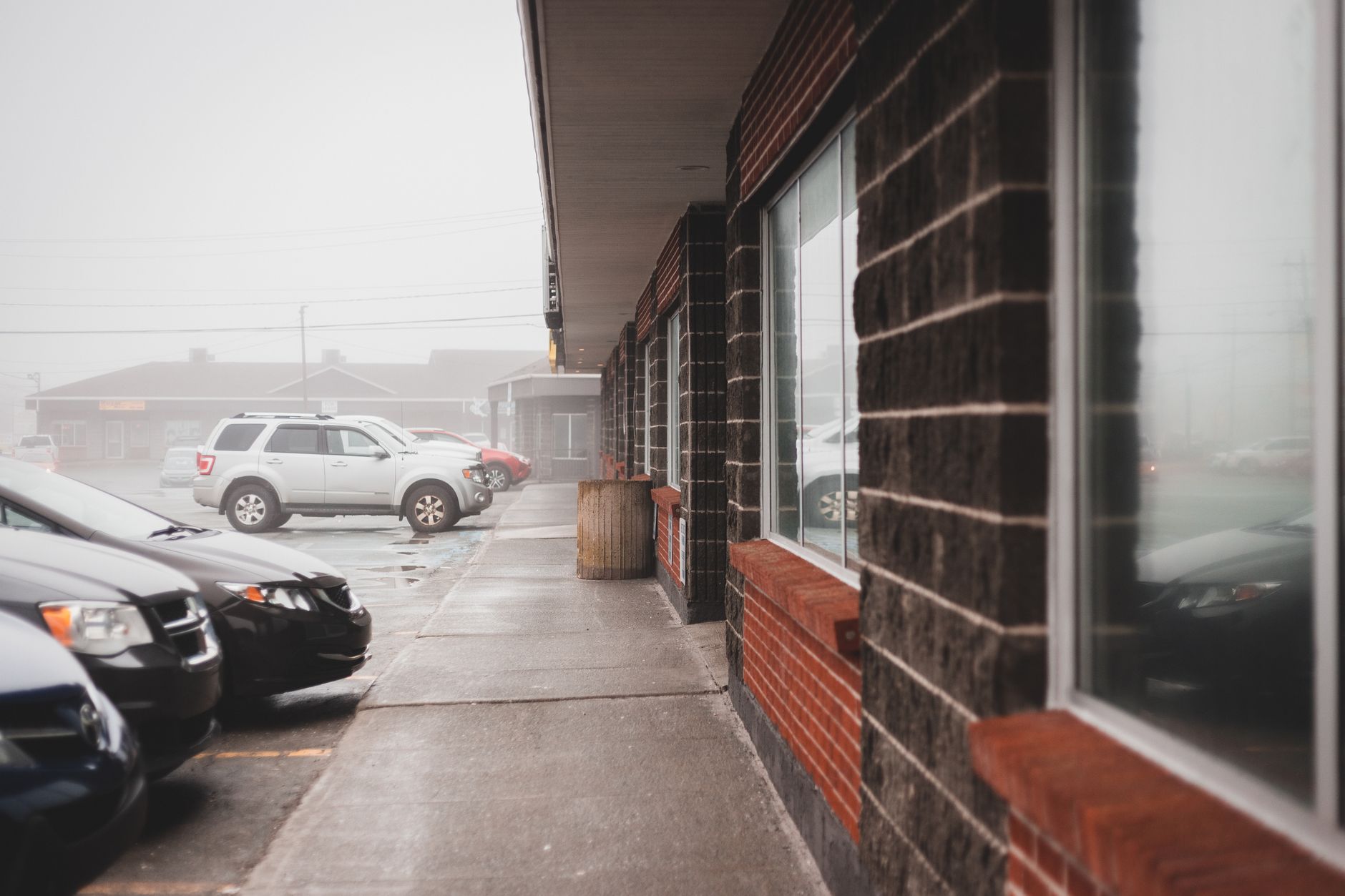 Rain-slick pavement in a store parking area, illustrating weather limits on outdoor retrieval.