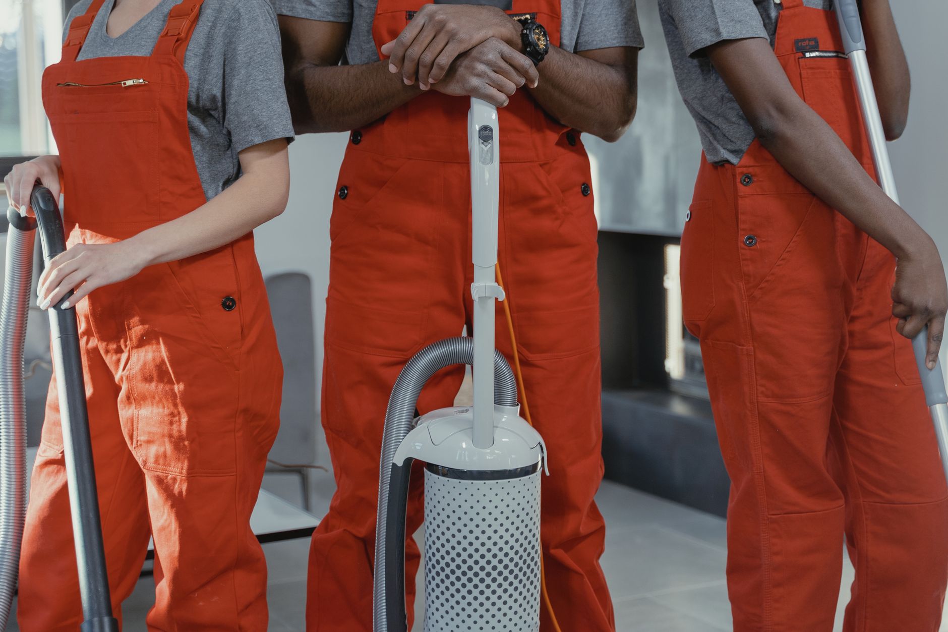 A member of a cleaning crew pushes a large trash receptacle down a venue hallway, illustrating the manual labor involved in post-event cleanup.