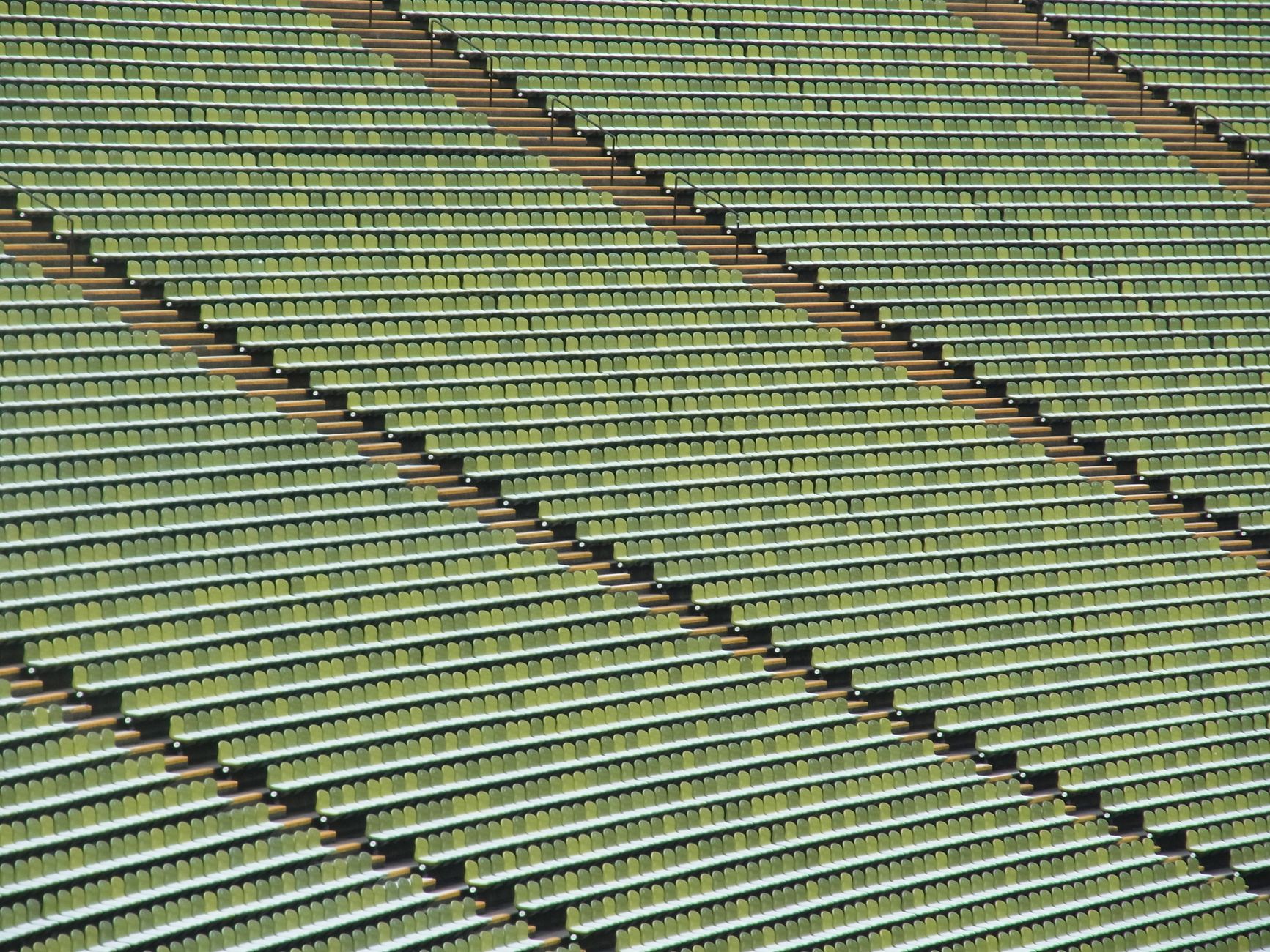 A wide shot of thousands of empty stadium seats after an event, highlighting the massive scale of the cleanup ahead for the venue.