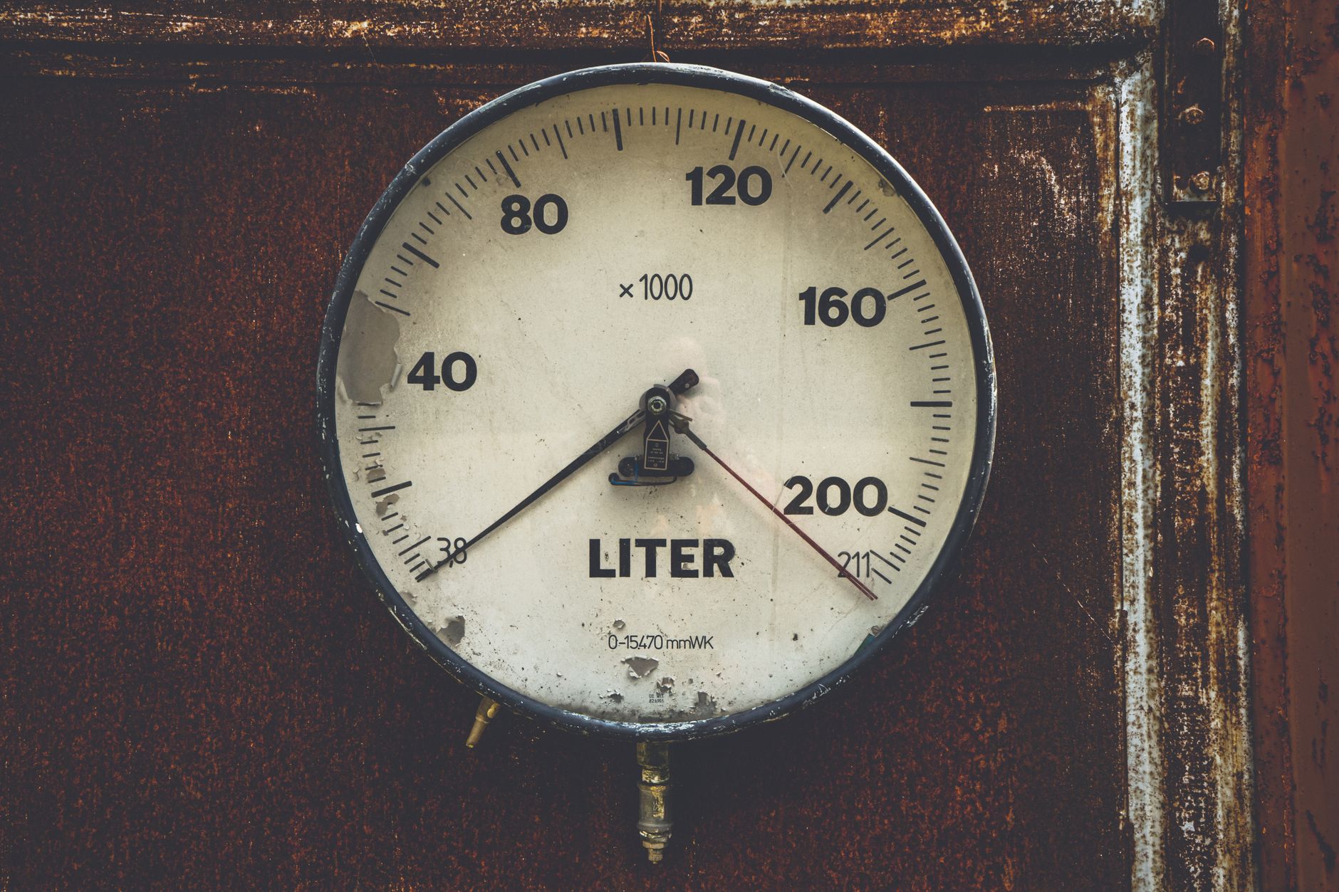A technician closely checks a pressure gauge as part of an equipment inspection.