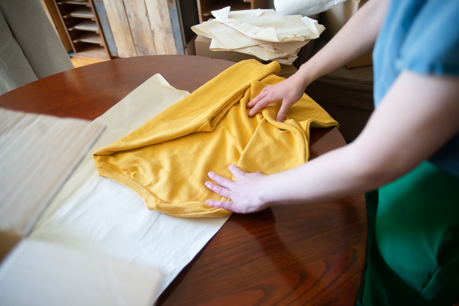 An employee reviewing stacks of towels at a worktable reflects the manual rechecks that sorting mistakes create downstream.