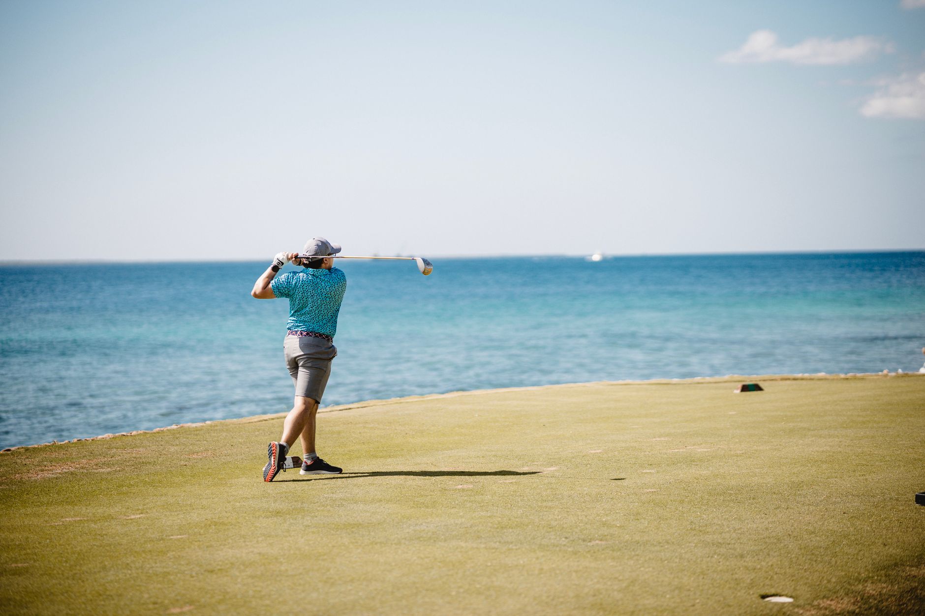 Golfers preparing to tee off during a late afternoon league block.