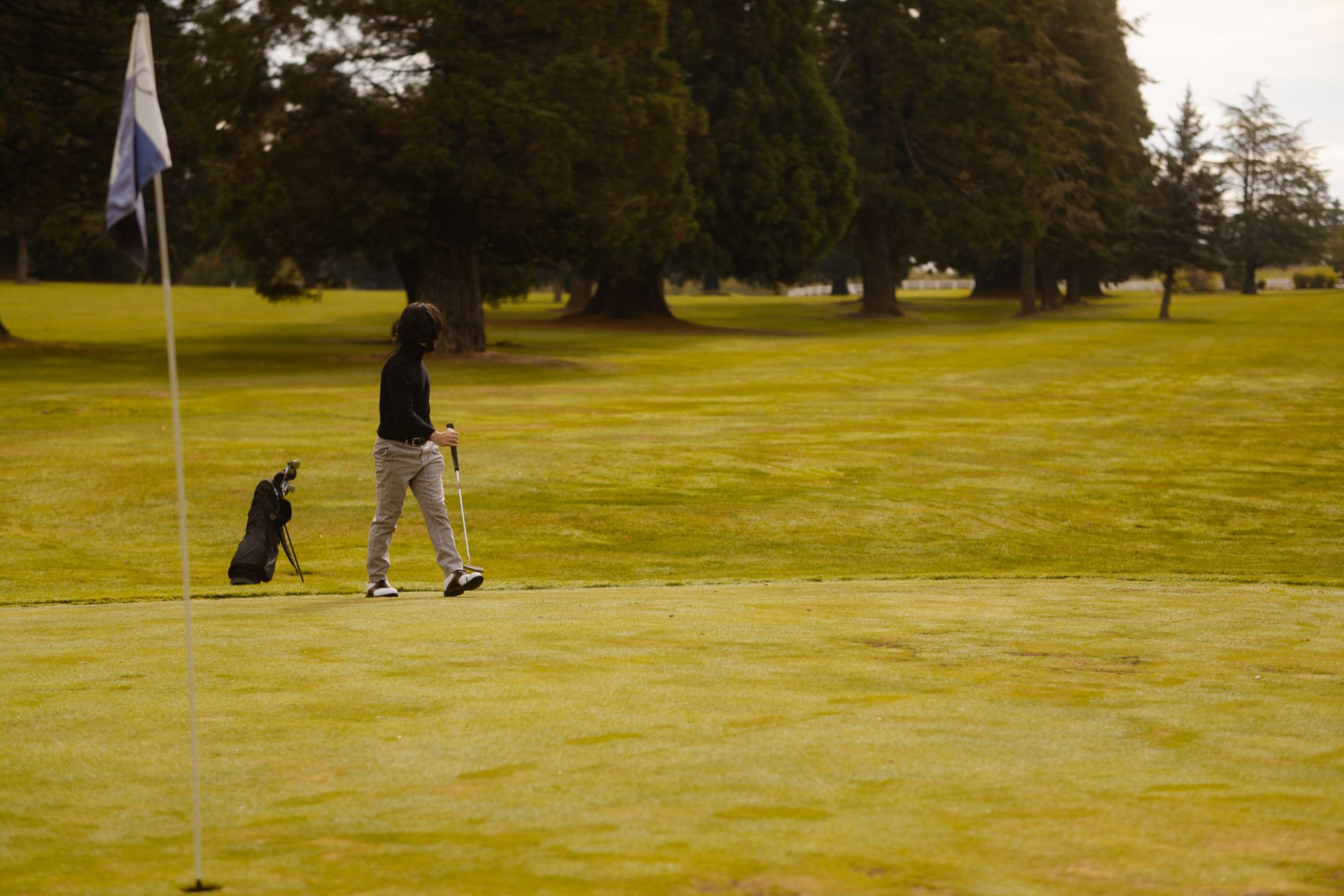 Superintendent walking a fairway to inspect ground conditions before unlocking robots.