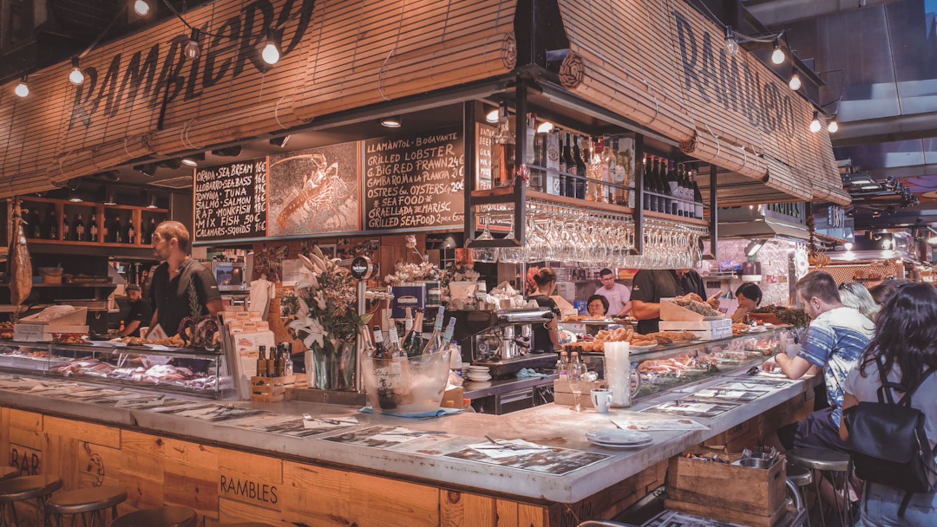 A loud, crowded bar scene reflects the noisy, high-interruption conditions where voice interfaces can become slower and less reliable.