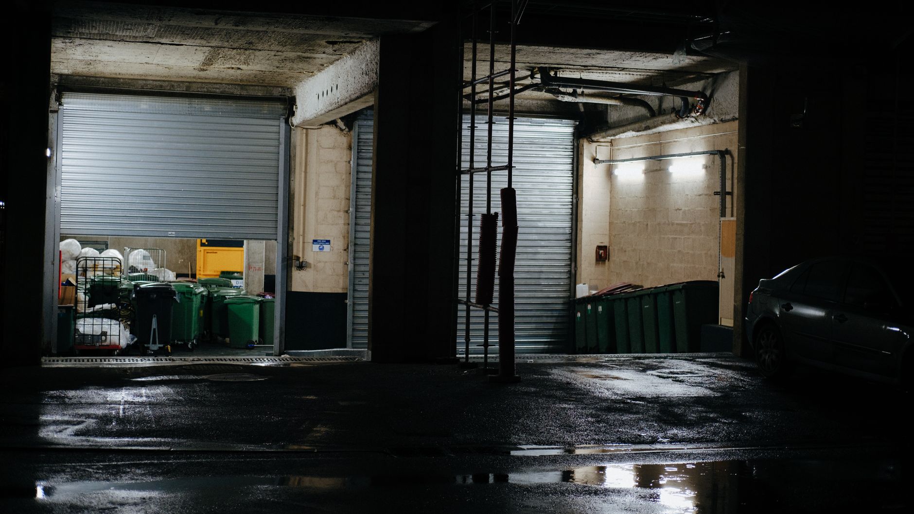A wet warehouse floor near a work zone, highlighting the slip hazards and cleanup pressure common around active loading docks.