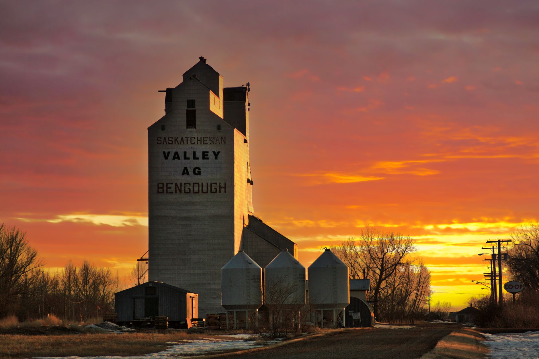 Grain elevator beside a rural highway at dusk