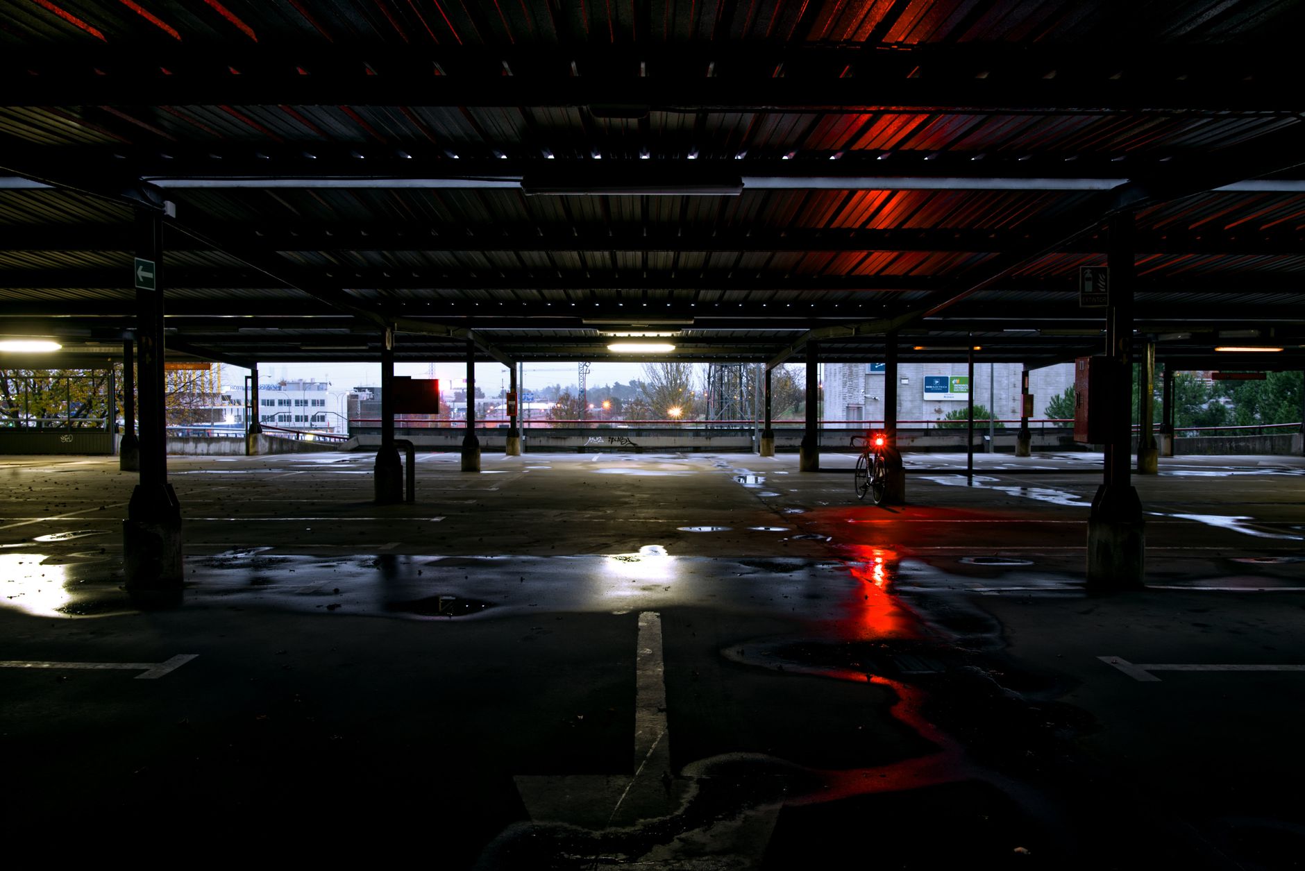 Standing water in a parking lane shows depth checks needed before an outdoor scrubber or AMR resumes routes.