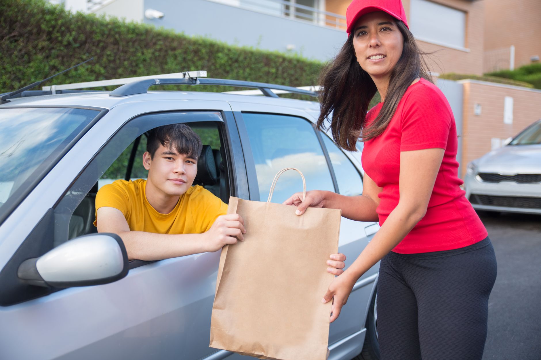 Students near a campus dining area with takeout bags