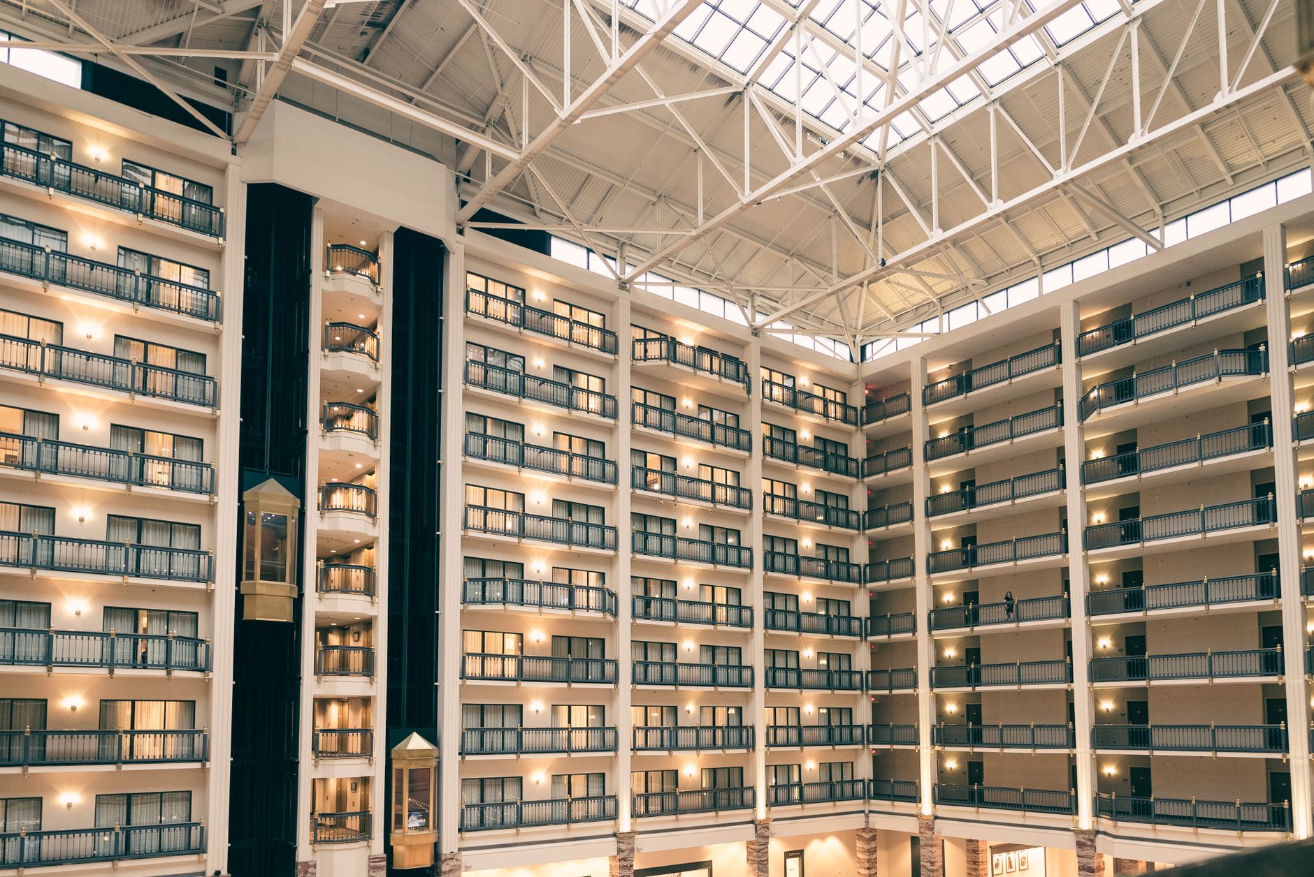 A multi-story hotel atrium where guests and staff share interconnected service areas.
