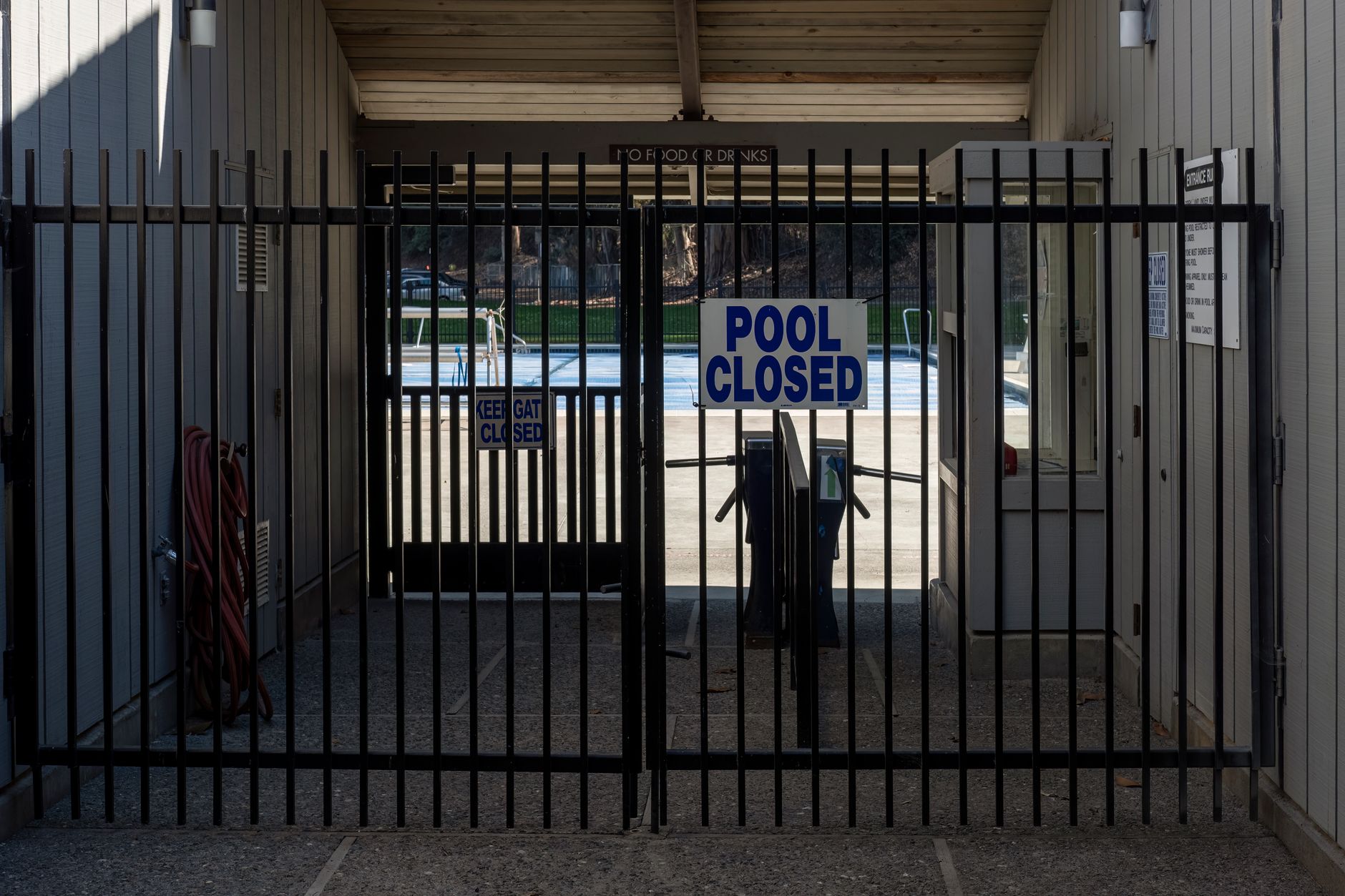 A closed pool gate and entry path at night, emphasizing the sightlines and access points that matter for overnight pool-area security.