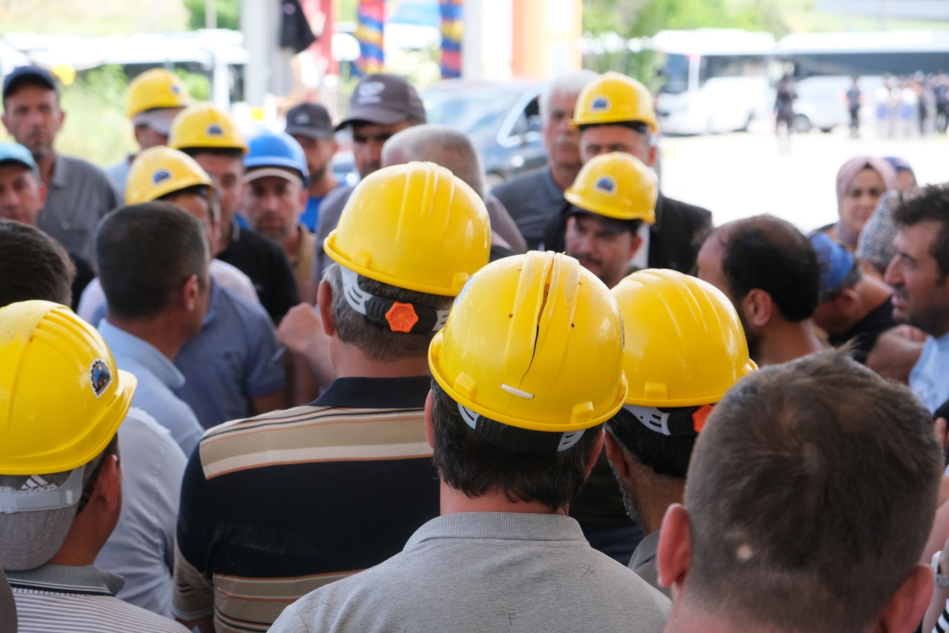 A facility manager leads a safety meeting, pointing to a diagram on a whiteboard to explain the new risk assessment process under ANSI/A3 R15.06-2025.