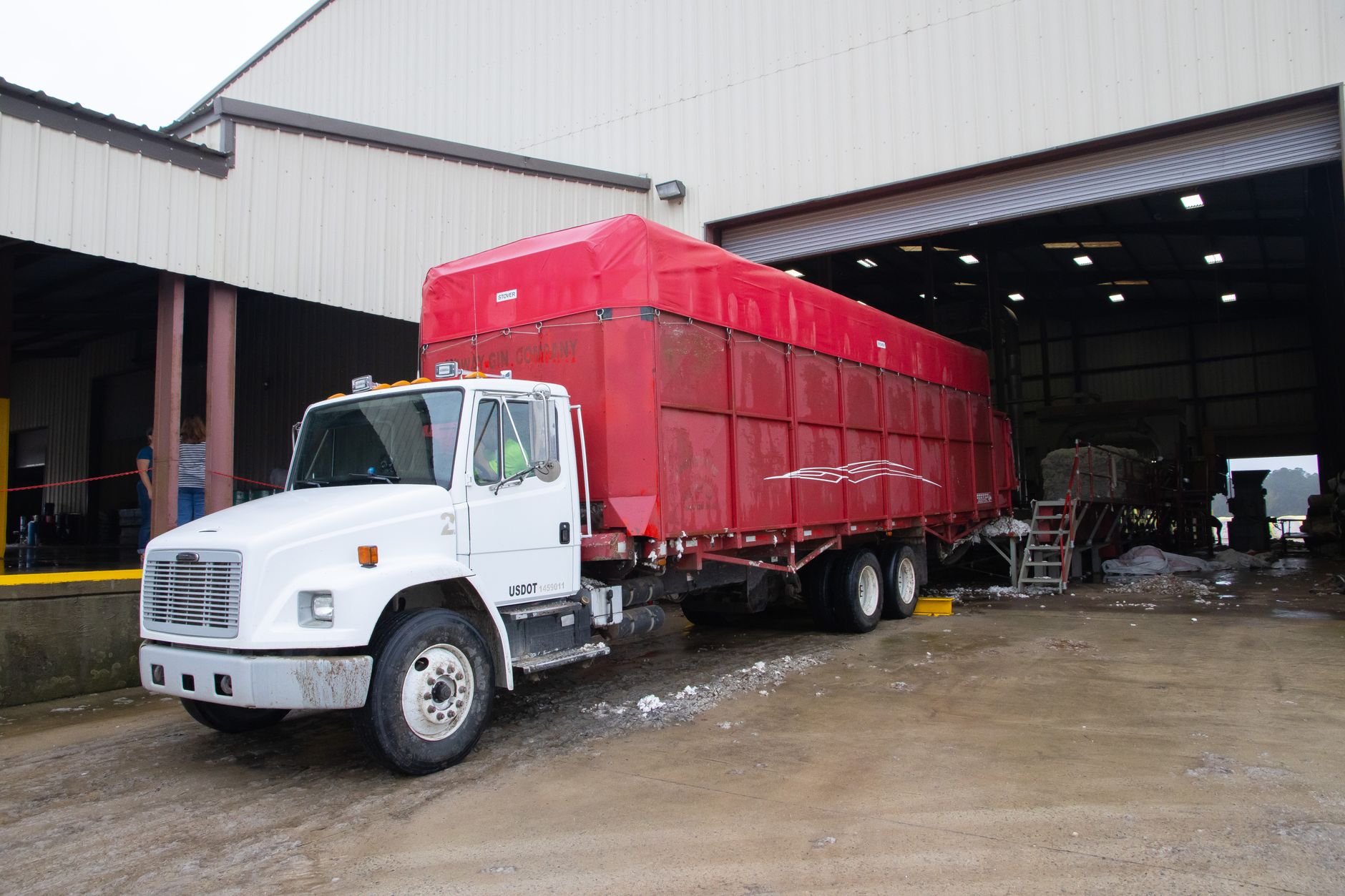 Trucks backed into a busy loading dock, showing the logistics volume and operational pressure behind rising warehouse technology investment.