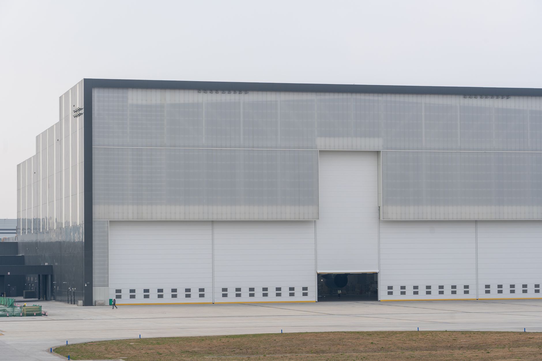 A wide, clean aisle in a modern distribution center, suggesting the large-scale environments where agentic automation will be deployed.