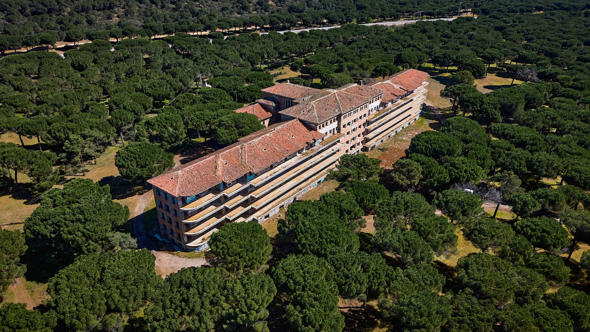 A modest community hospital building with parking and landscaping, representing the scale of rural facilities evaluating floor-care automation.