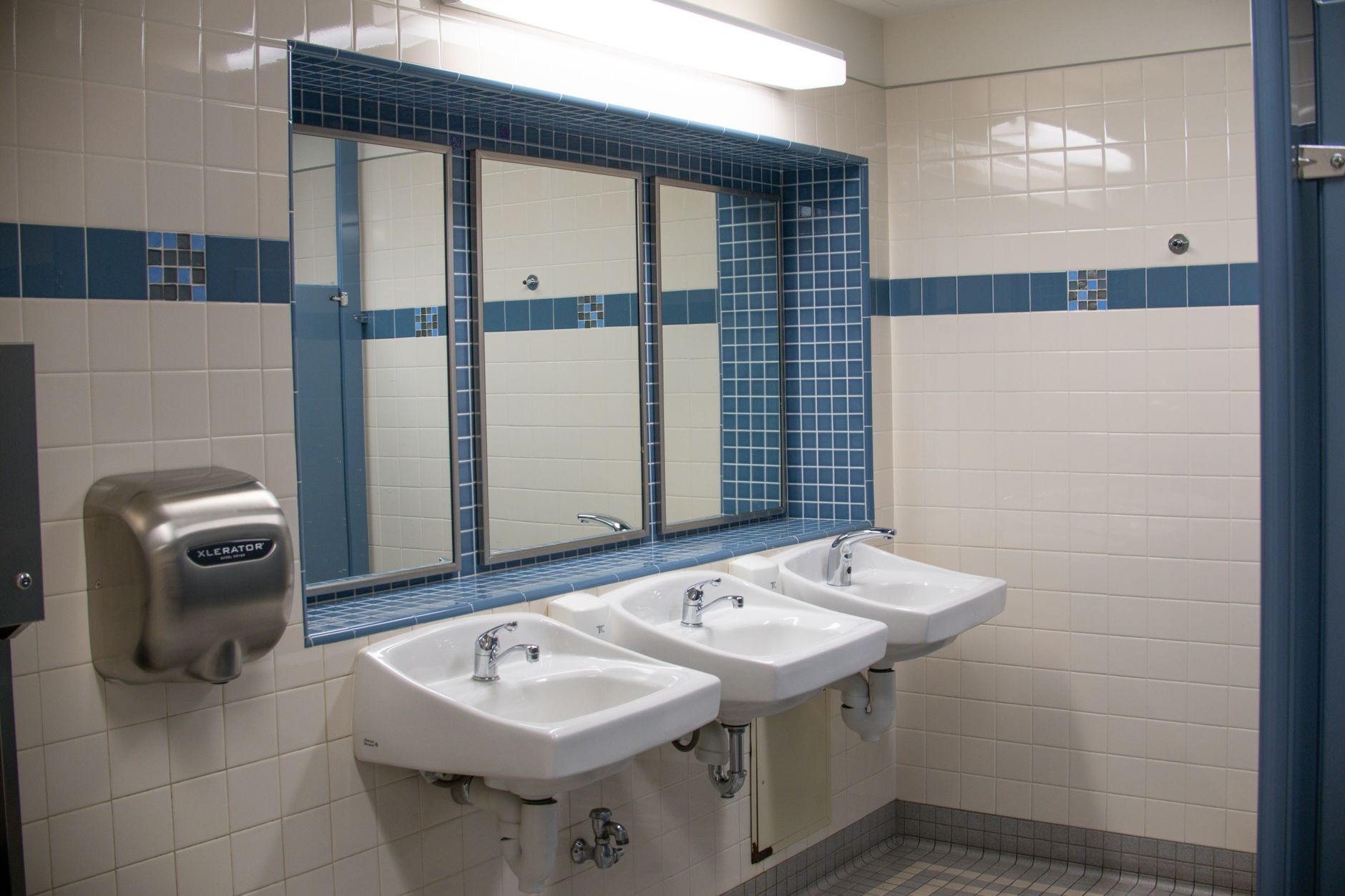 A clean public restroom wash area that illustrates the high-touch service expectations airports still need staff to manage.