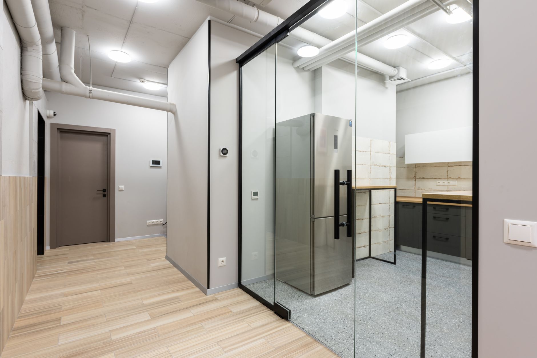 A cleaner works through a quiet commercial hallway, illustrating the kind of standardized overnight floor-care environment a franchise robot program must support.