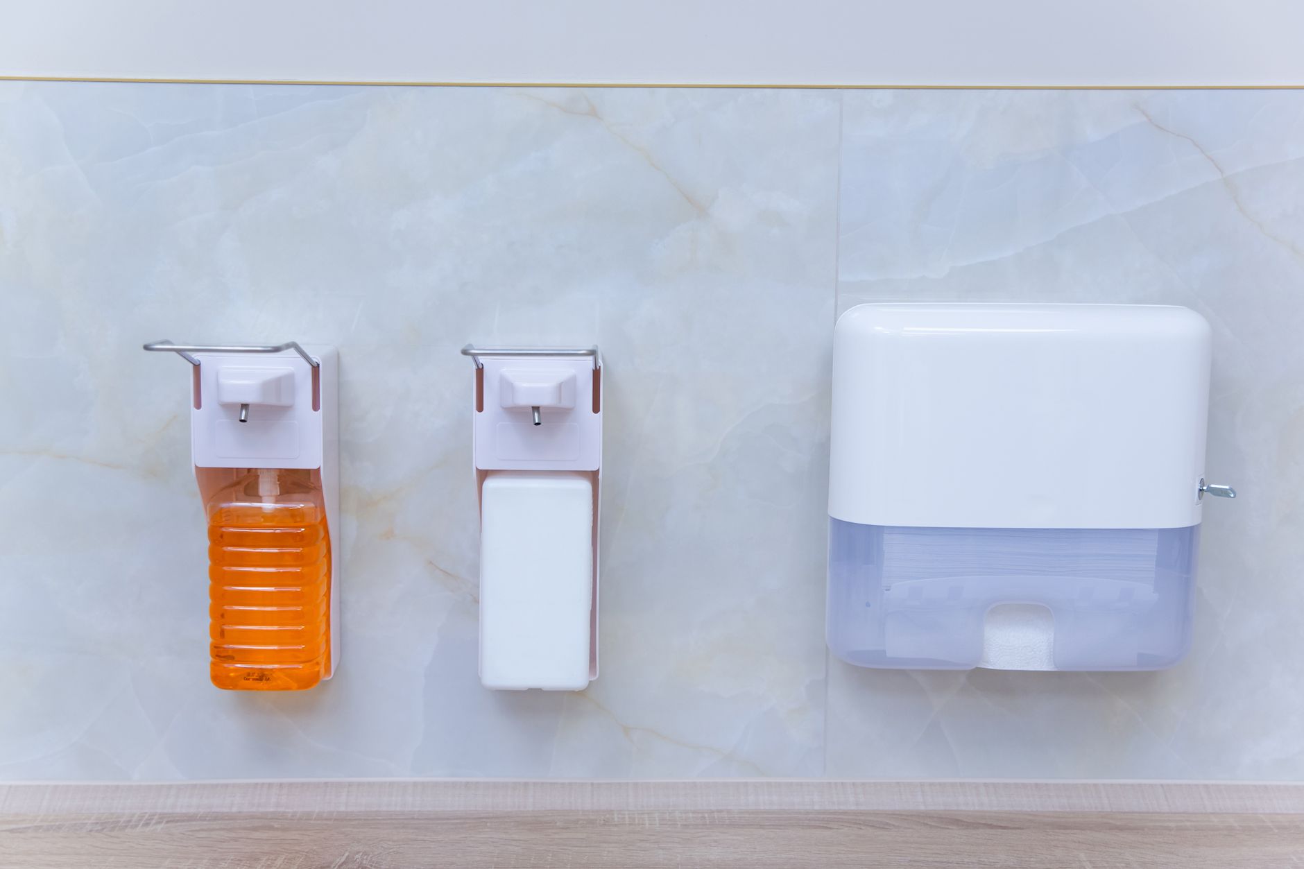 Hand sanitizer dispensers mounted along a clinic wall