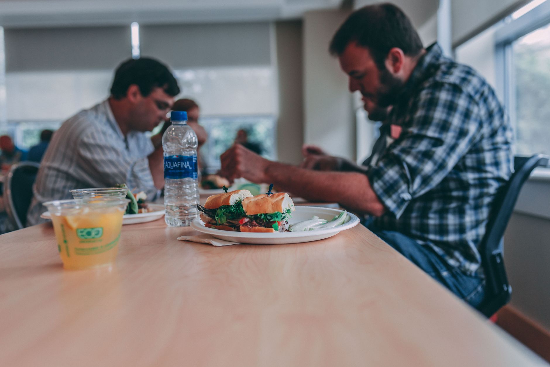 A crowded lunch-period dining area with uneven traffic through aisles and seating, matching the surge patterns food halls have to manage.