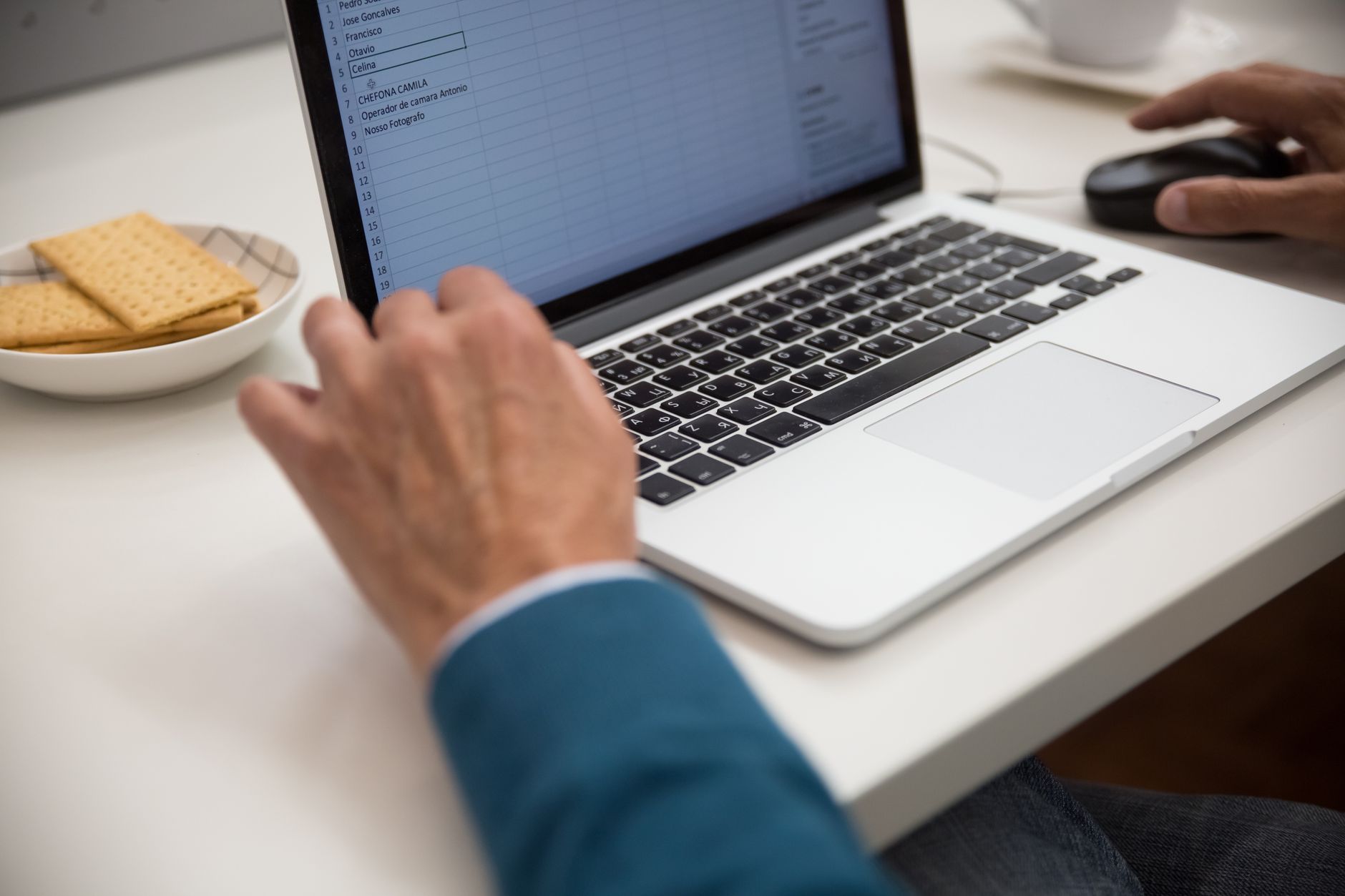 A laptop open to a cost spreadsheet, matching the article's focus on a monthly dashboard for energy, demand, and utilization.
