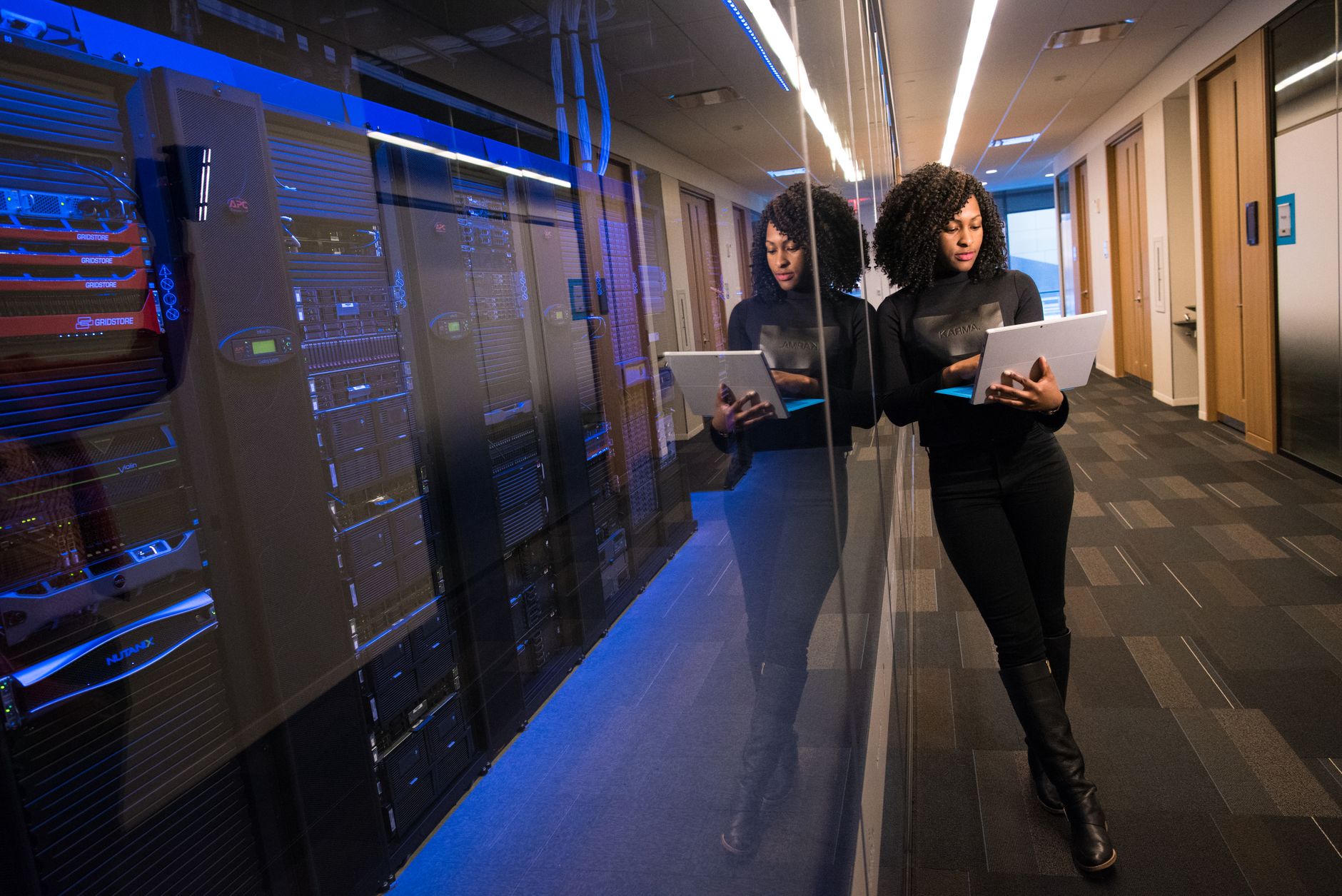 Rows of network servers behind glass, evoking firmware, cloud maps, and security updates that must stay current through end of life.