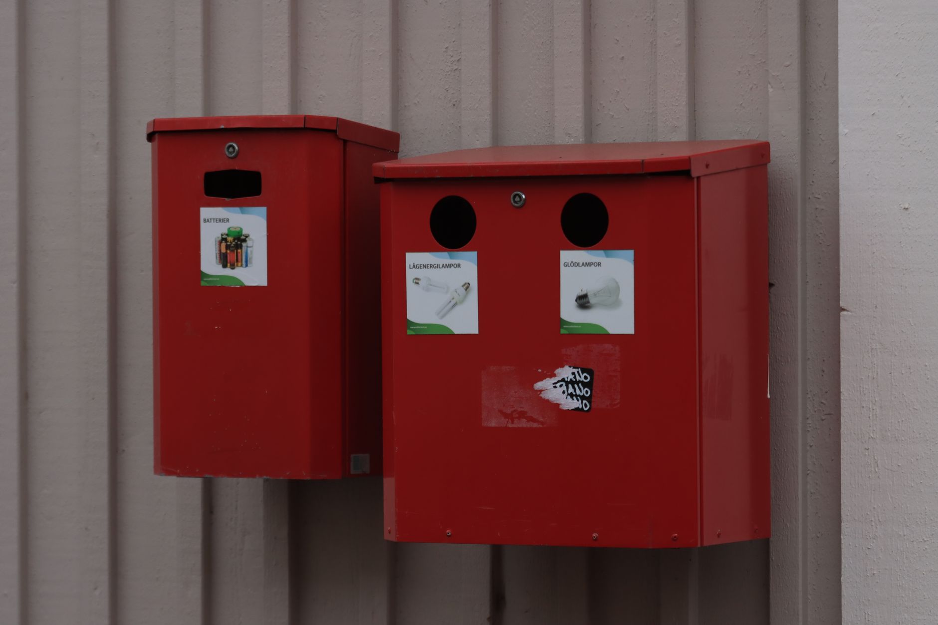Labeled collection bins for used batteries, reflecting universal waste handling before robot packs ship to a recycler.