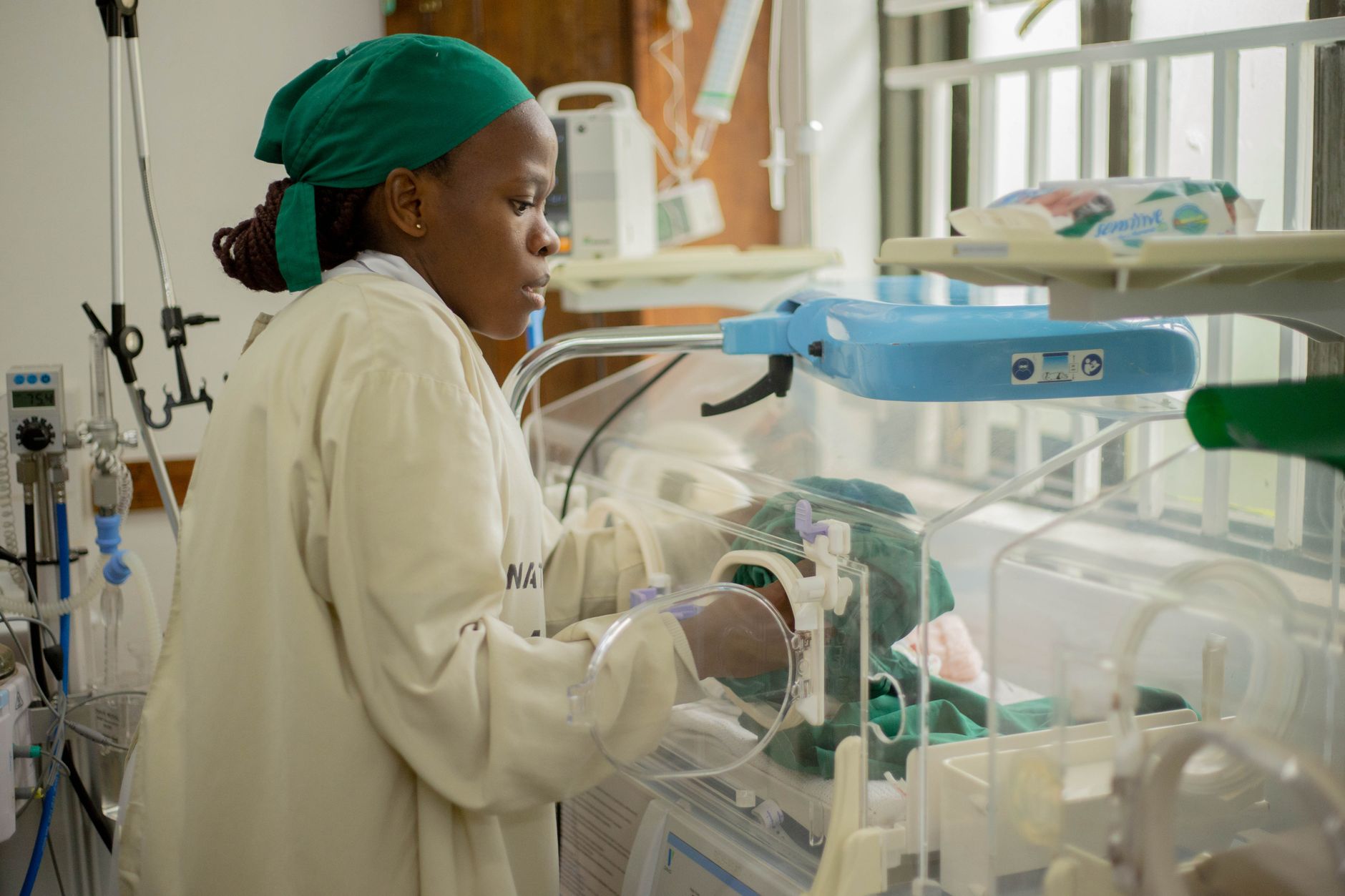 A nurse walking through a hospital corridor near patient care areas