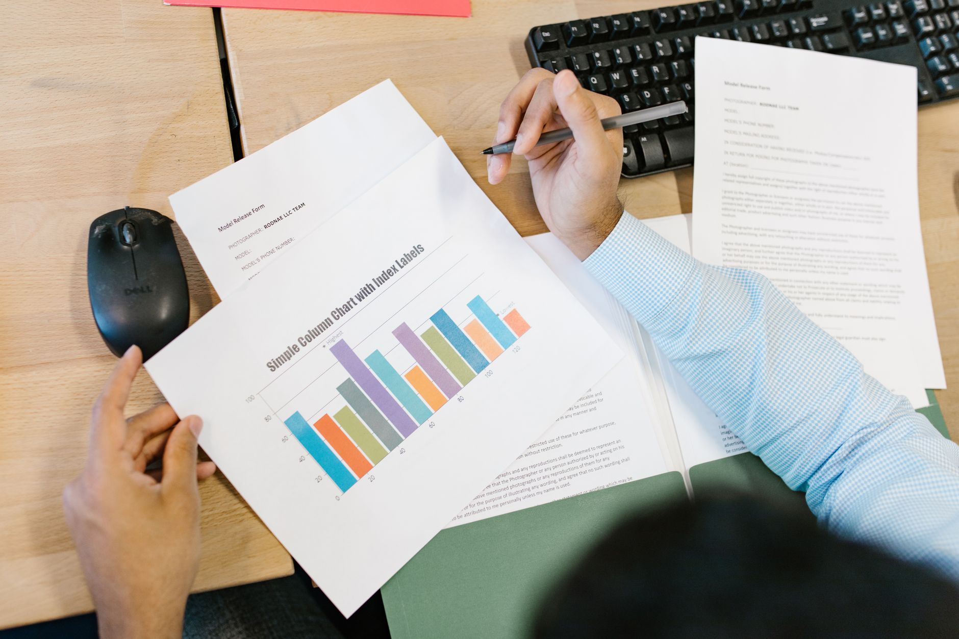 Analyst reviewing separate data panels on a laptop screen while comparing two sets of figures.