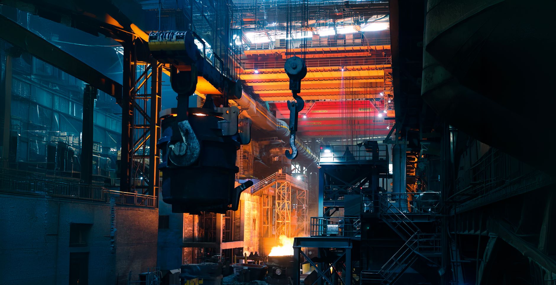 Wide view of a working foundry floor with long aisles, casting stations, and heavy industrial infrastructure, grounding the article in real production conditions.