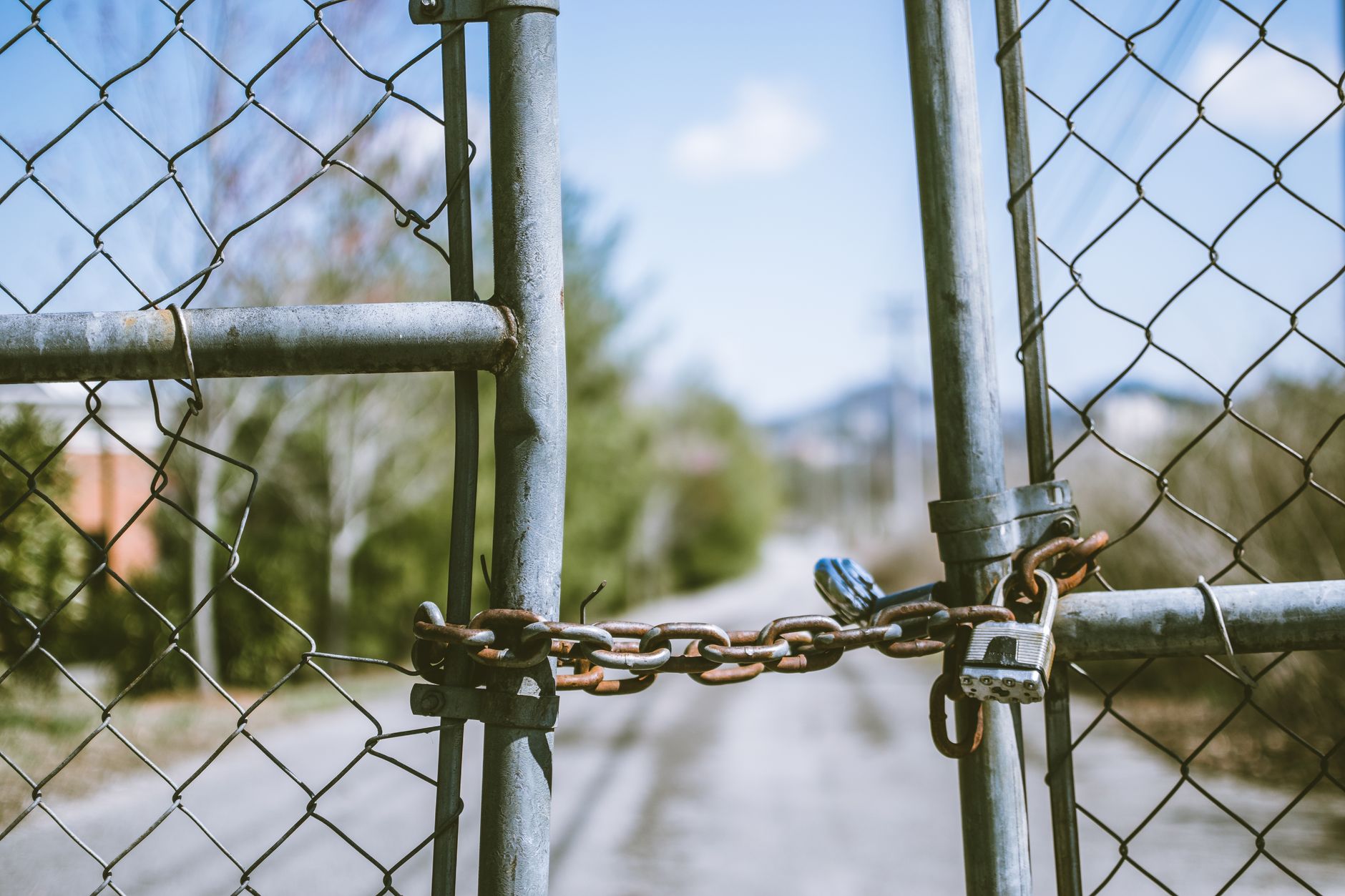 A latched perimeter gate along a school-side path, representing the kind of simple after-hours checkpoint a campus pilot should verify.
