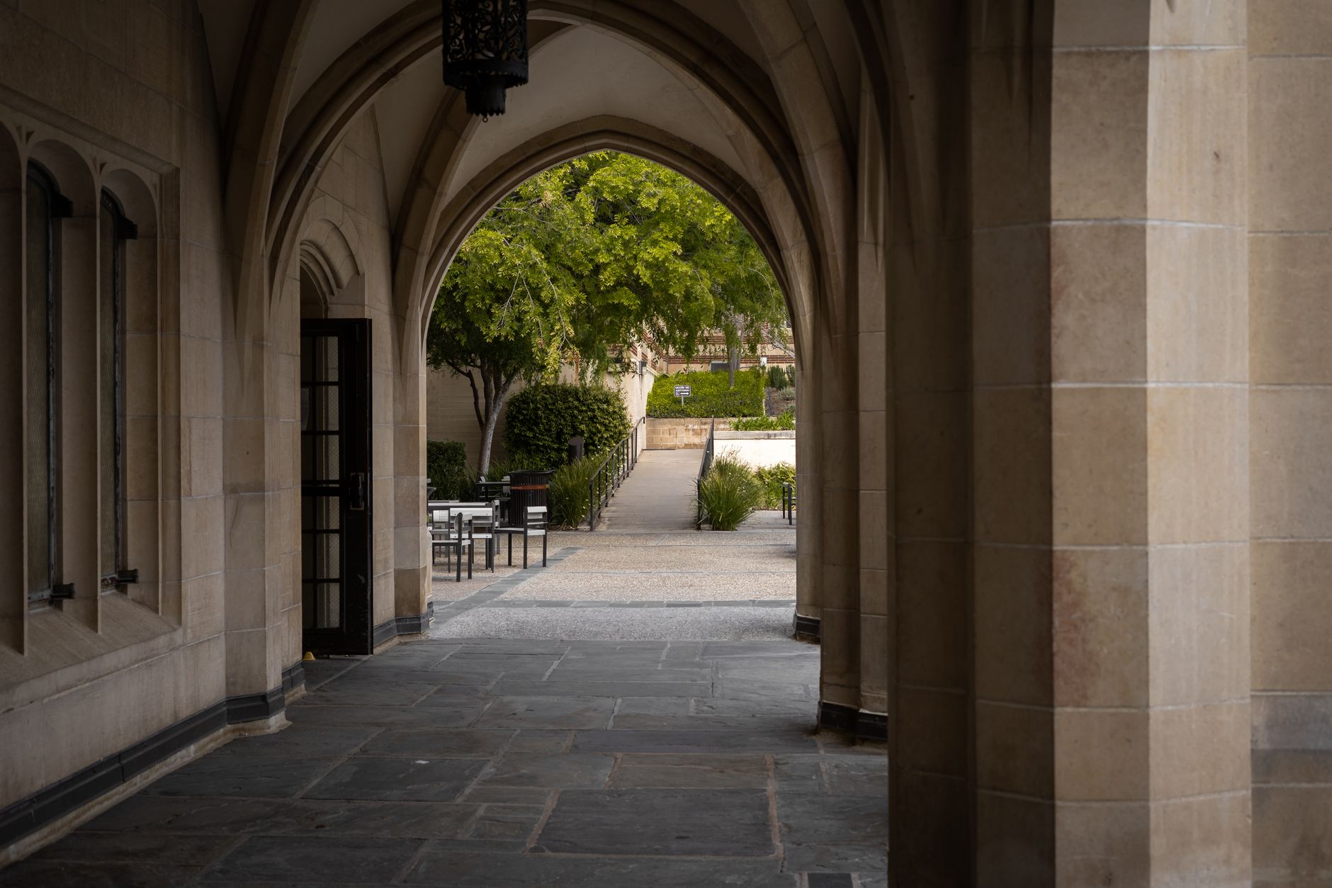 Students walk along a broad campus path between academic buildings, showing the exterior ground that fixed cameras do not always cover well.
