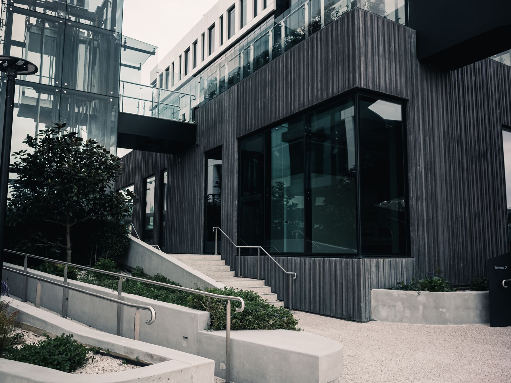 A set of outdoor concrete stairs on a modern corporate plaza, representing a common obstacle that quadruped robots are designed to overcome.