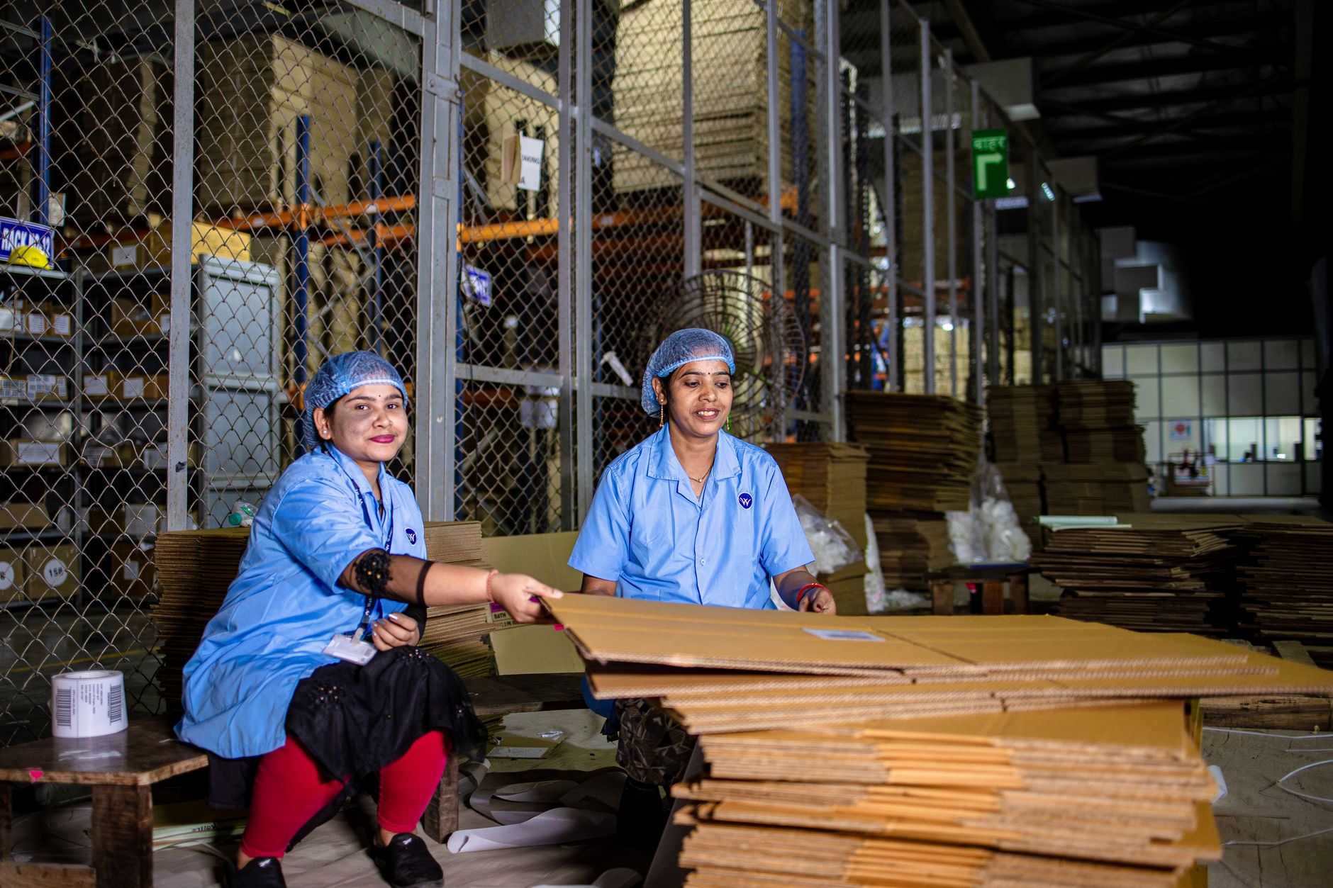 Workers at a manual packing line where new hires need coaching to keep boxes moving consistently.