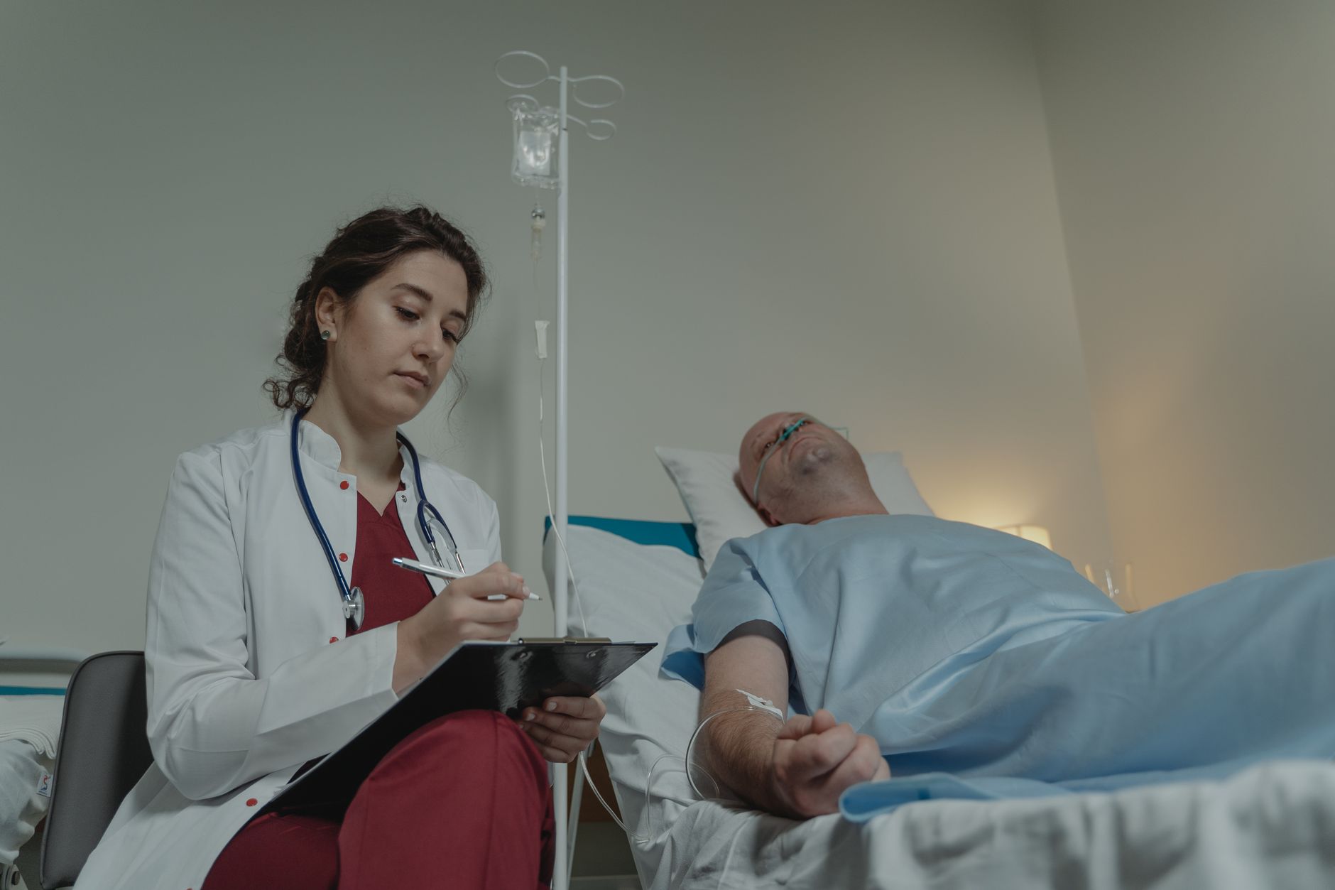 Nurses working at a hospital charting station, showing the clinical attention that gets pulled away when transport work spills onto licensed staff.